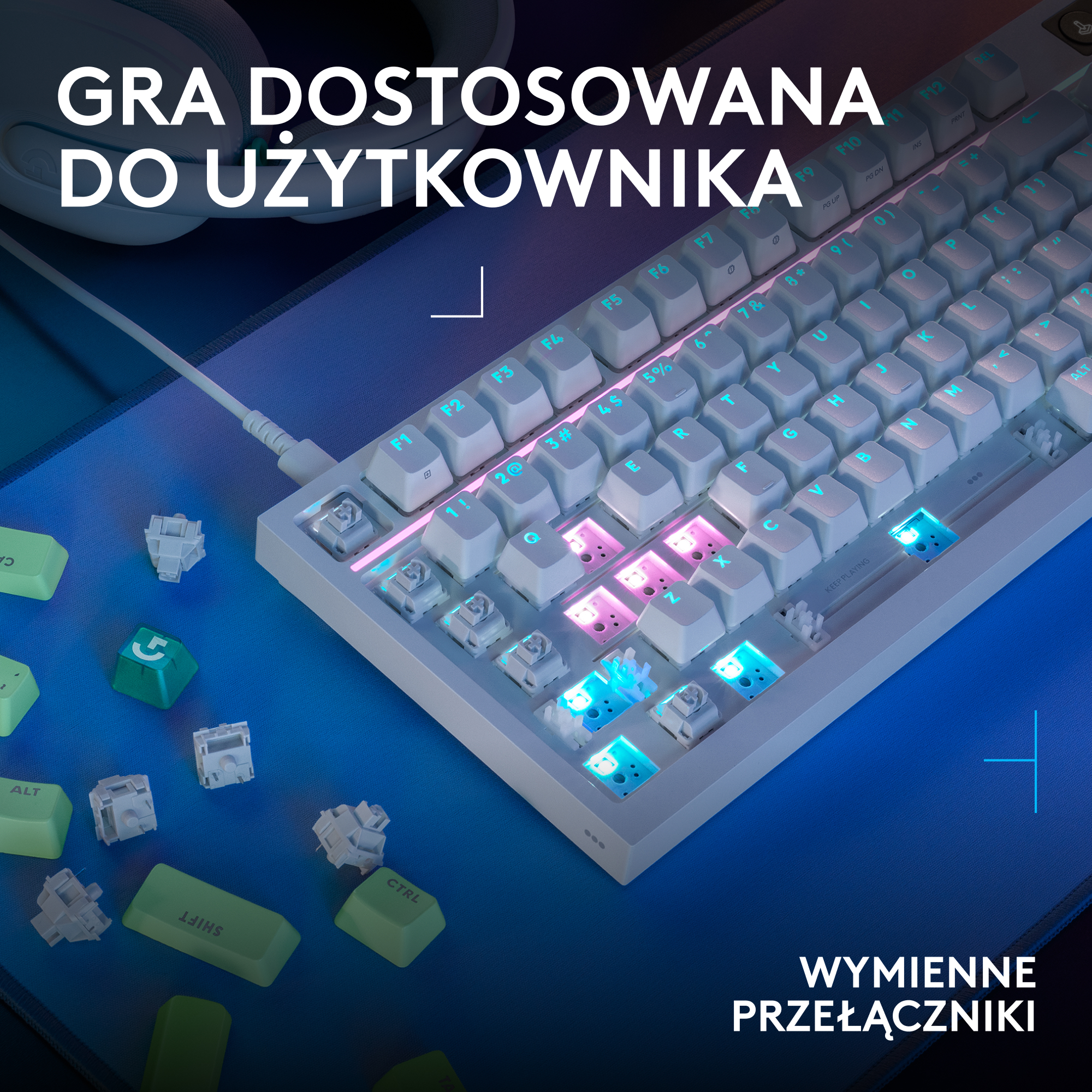 Biała klawiatura z podświetleniem RGB leży na niebieskiej macie.