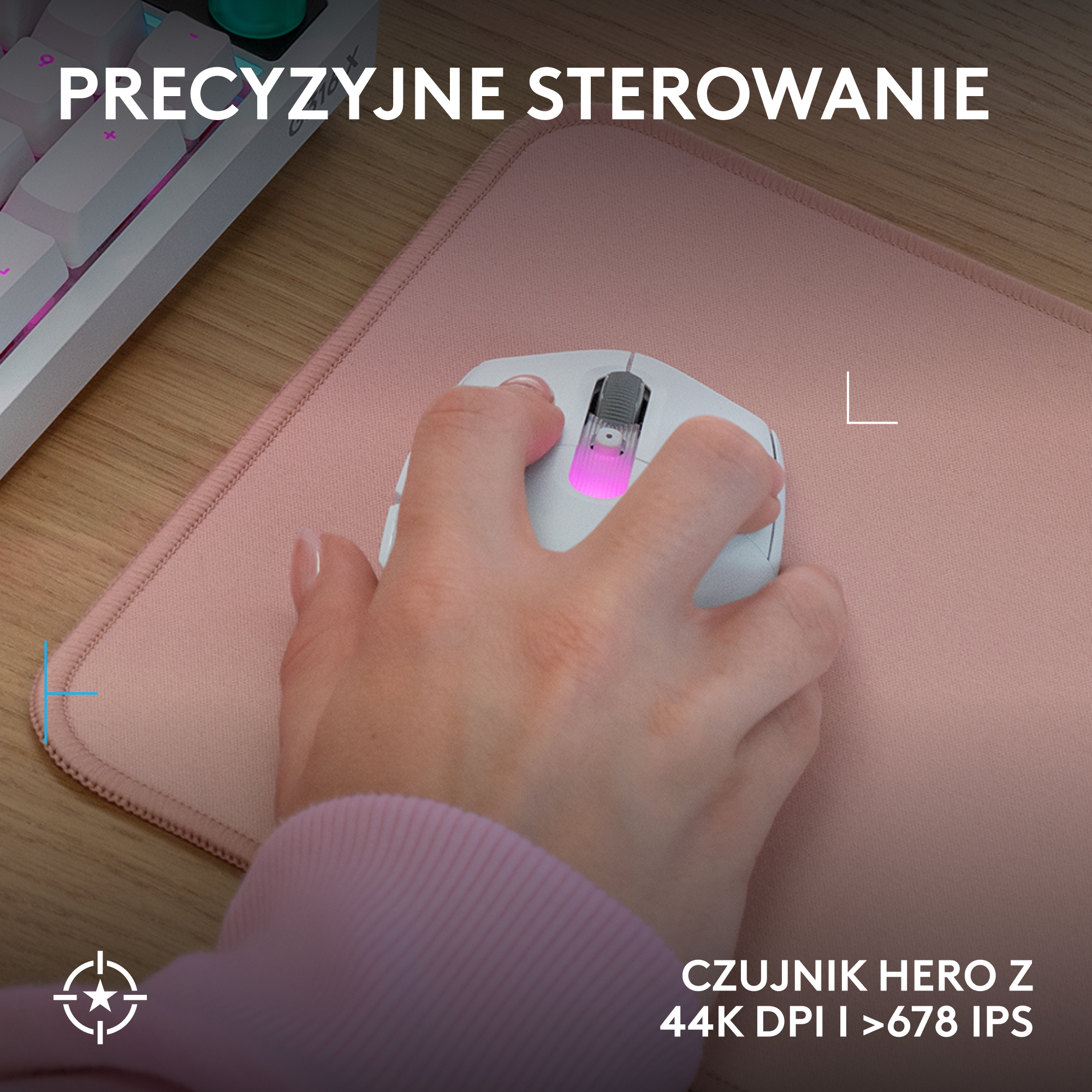 Dłoń trzyma białą myszkę gamingową z różowymi światłami na różowej podkładce. W tle znajduje się biała klawiatura.