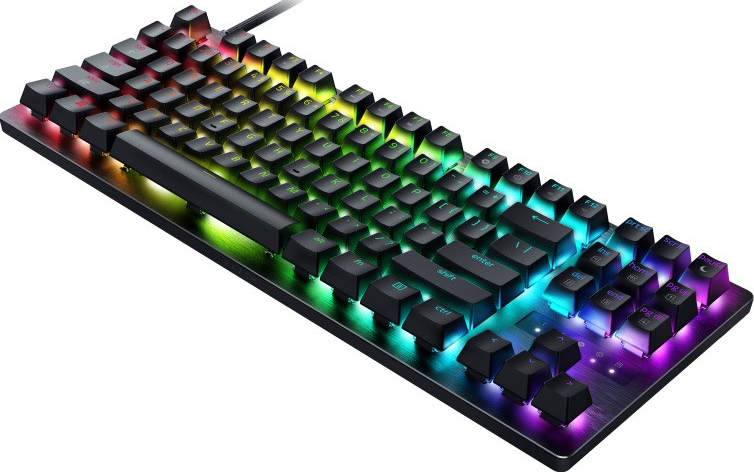 Una tastiera meccanica nera con illuminazione RGB emana vivaci tonalità verdi, blu e viola.