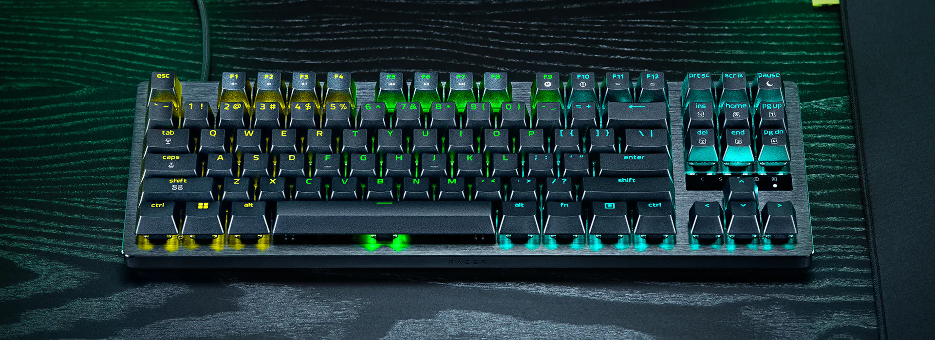 Una tastiera nera con illuminazione RGB, che brilla di giallo, verde e blu.