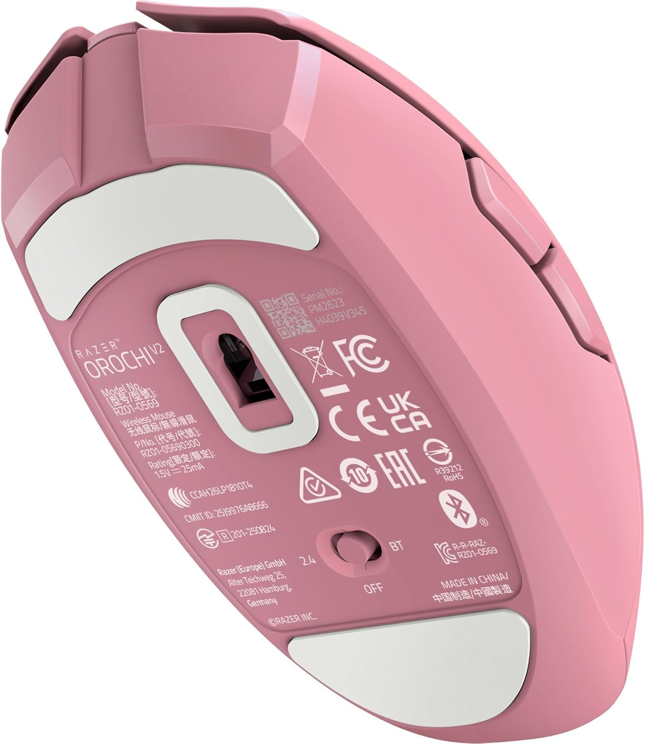 Die Unterseite einer pinken Razer Orochi V2 kabellosen Maus mit weißen Füßen, zeigt regulatorische Informationen und Modelldetails.