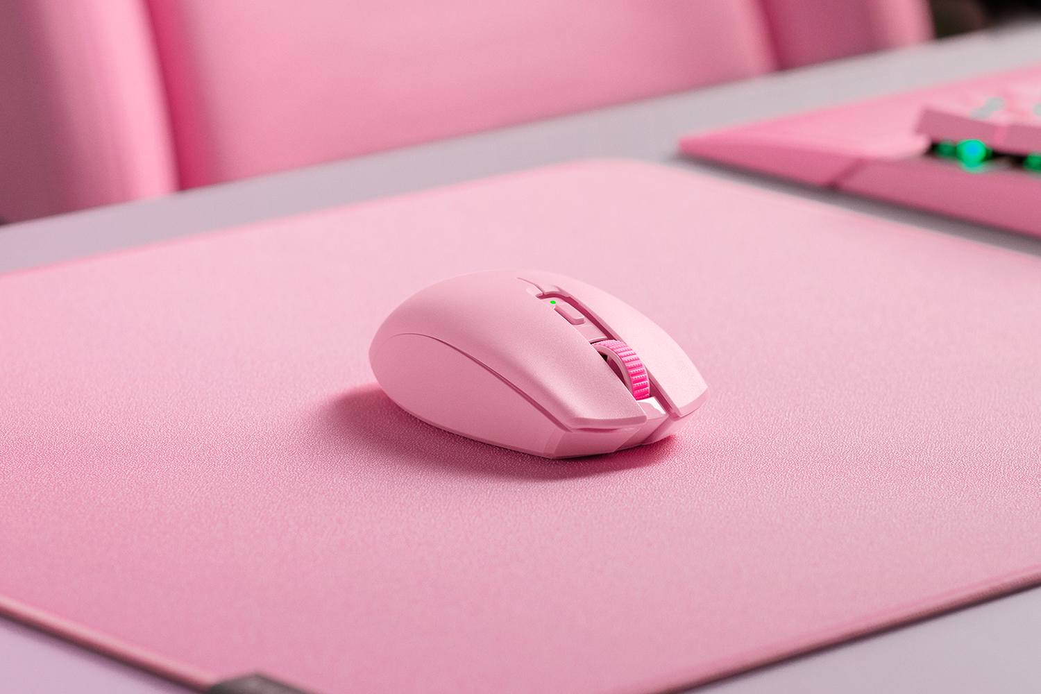 Eine rosafarbene Maus liegt auf einer rosafarbenen Unterlage, daneben eine Tastatur.