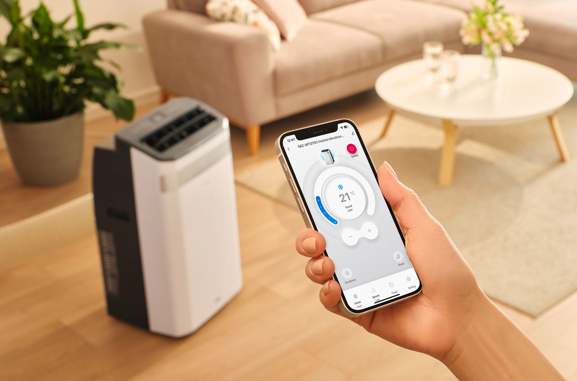 Smartfon steruje przenośną klimatyzacją ustawioną na 21 stopni i niską prędkość.