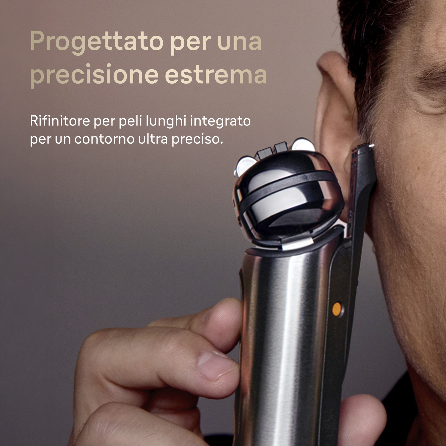 Un uomo usa un rifinitore di precisione vicino al suo orecchio. Il rifinitore è argentato con accenti neri.