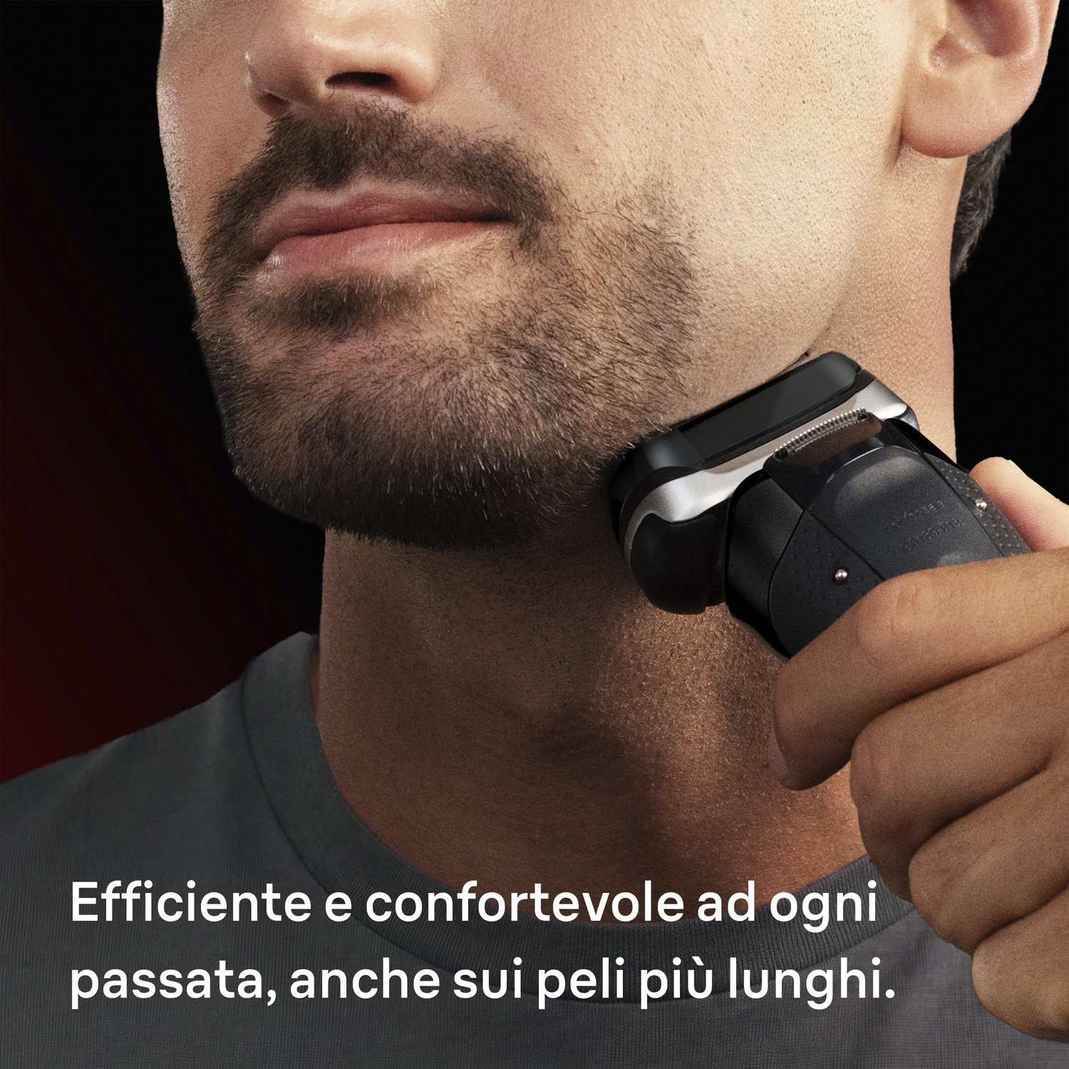 Un uomo si rade il mento e il collo con un rasoio elettrico.