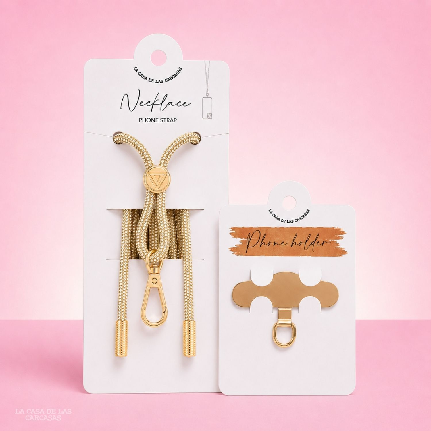 Cinturino dorato per collana per telefono e porta telefono su cartoncini bianchi su sfondo rosa.