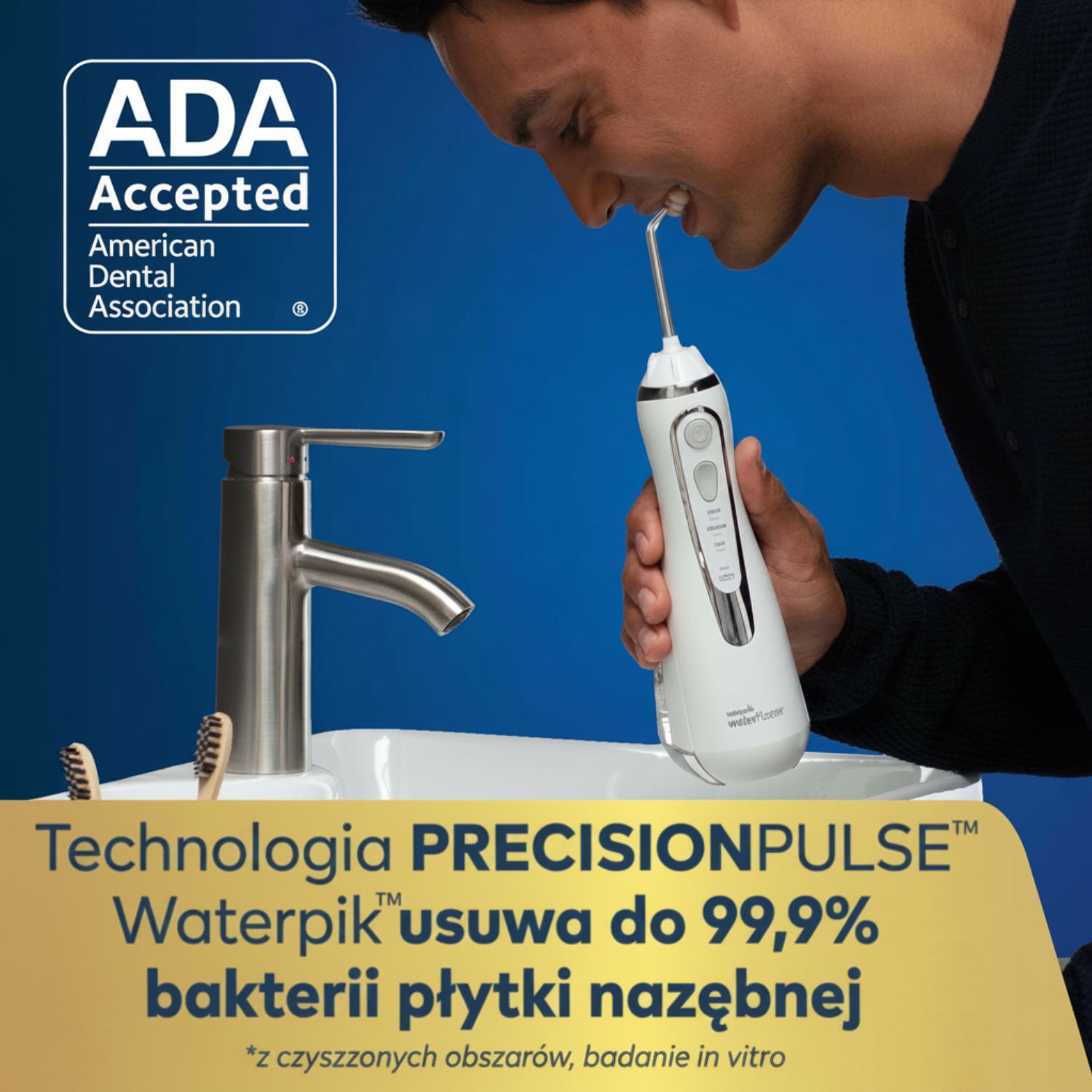 Mężczyzna używa irygatora Waterpik nad umywalką z kranem.
