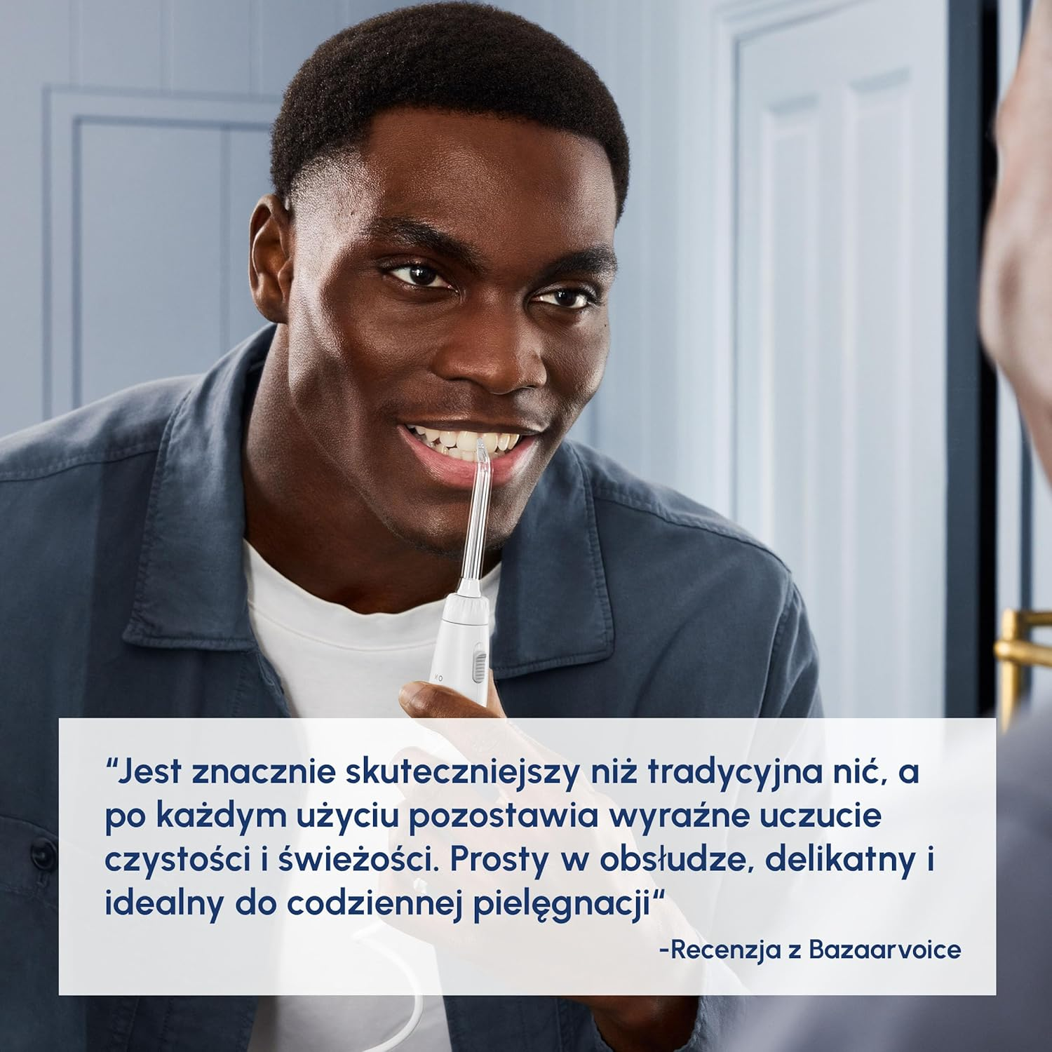 Mężczyzna używa irygatora do czyszczenia zębów.