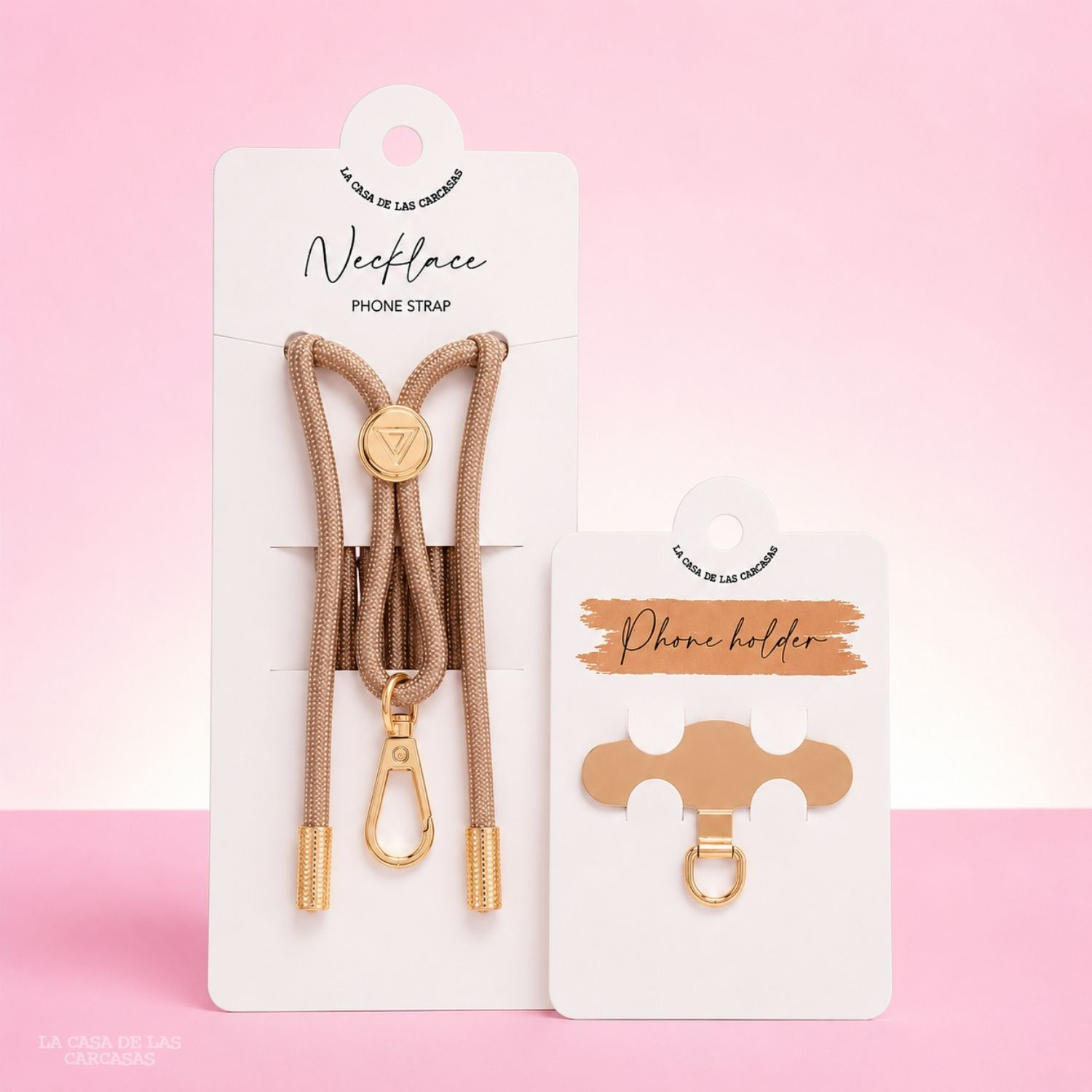 Cinturino per telefono a collana dorato e supporto per telefono su cartoncini bianchi su sfondo rosa.