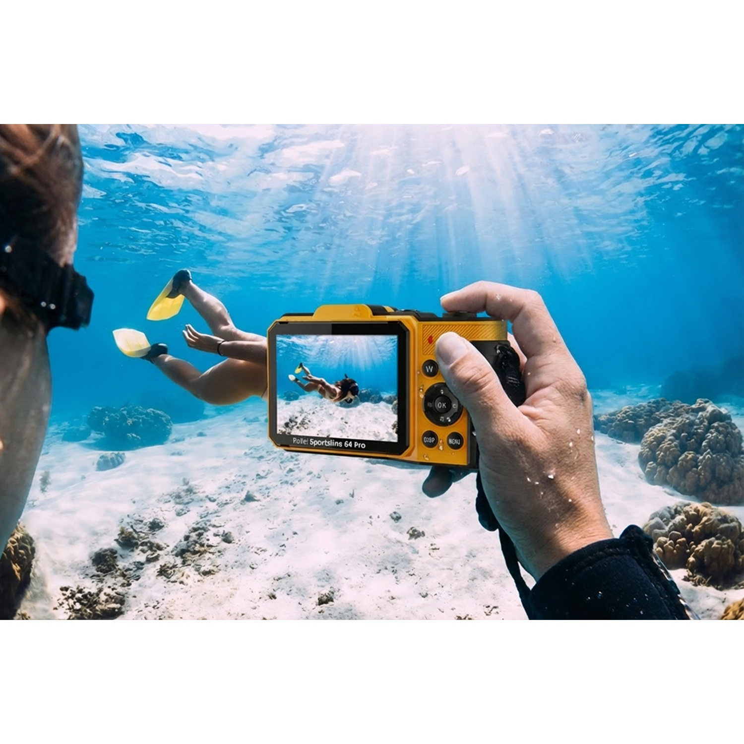 Mano tiene macchina gialla sott'acqua, riprende snorkelista con pinne.