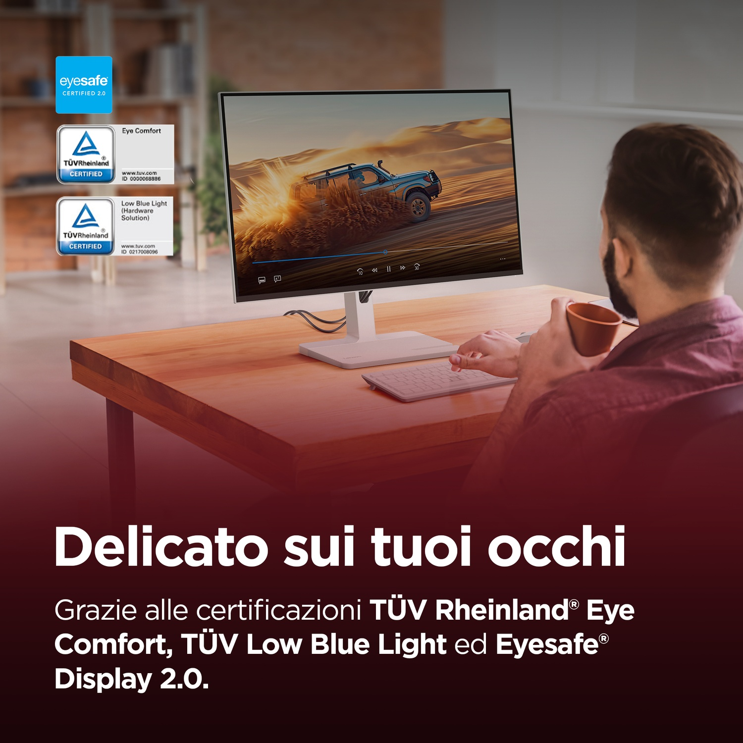 Uomo guarda monitor con scena di corse nel deserto, certificazioni a sinistra.