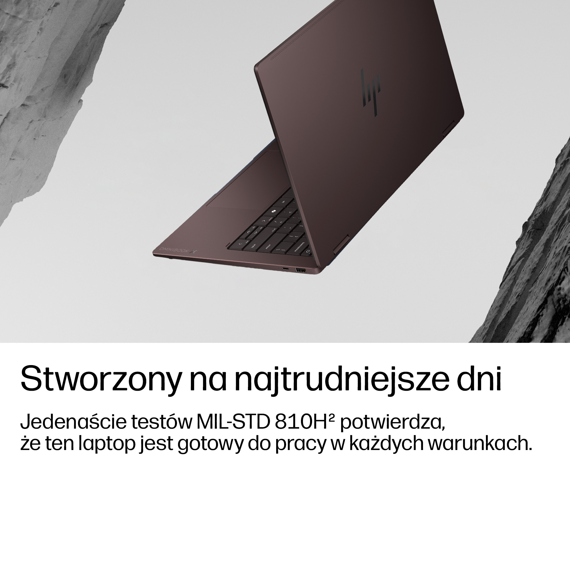 Ciemnoczerwony laptop HP z klawiaturą jest otwarty. Skaliste tło.