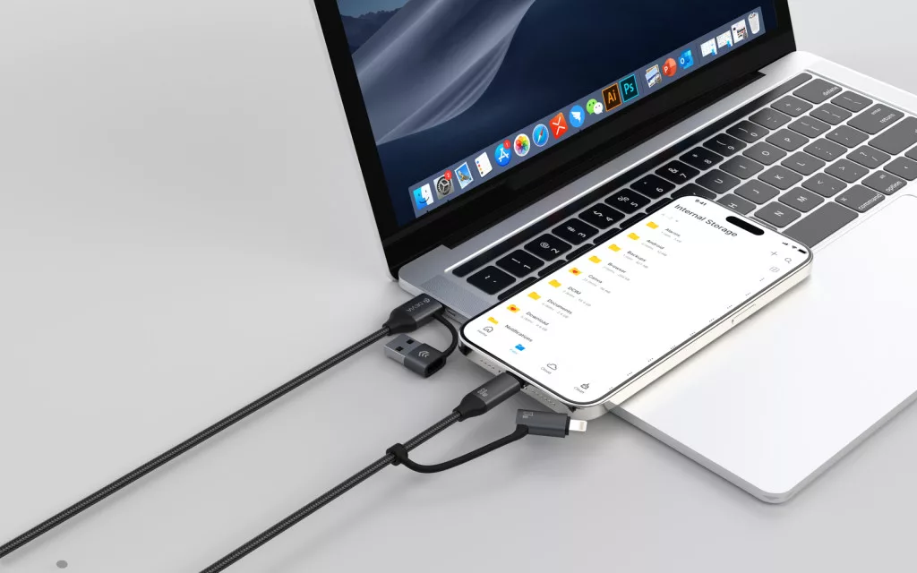 Egy laptop USB-C és USB-A hubokon keresztül csatlakozik egy okostelefonhoz. A kábelek feketék.