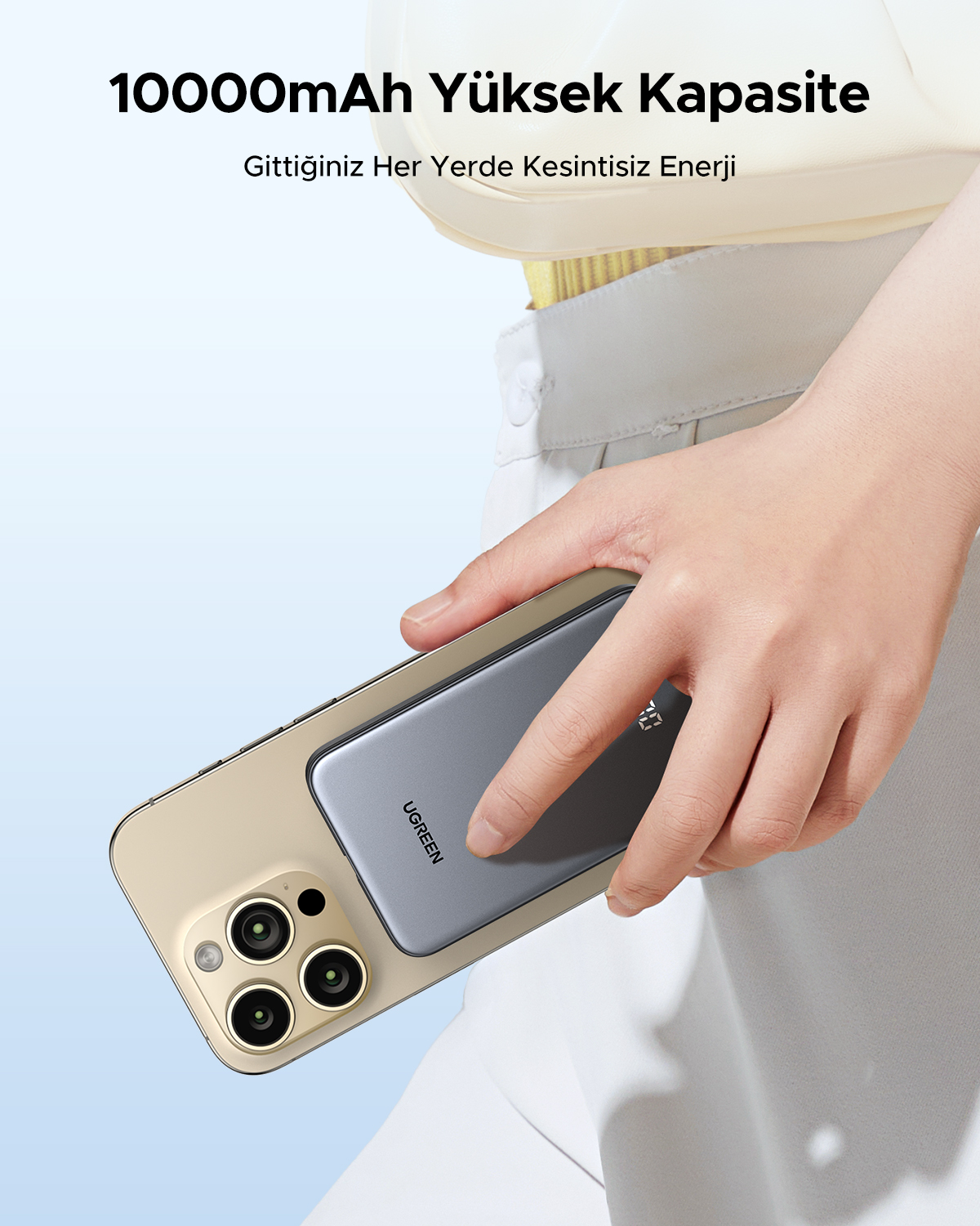Bir el, takılı gri powerbank ile bir akıllı telefon tutuyor.