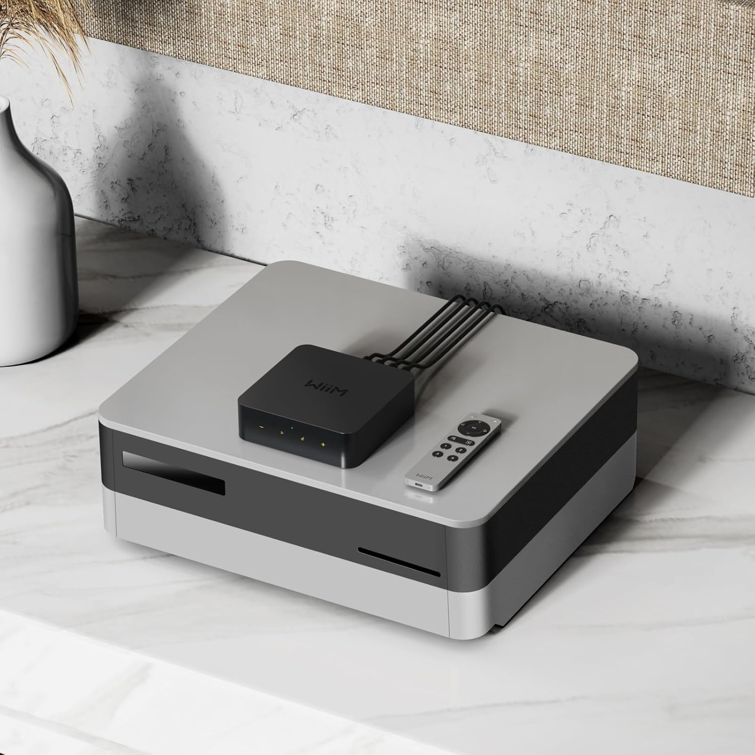 Un appareil Wiim noir avec une télécommande sur une boîte grise.