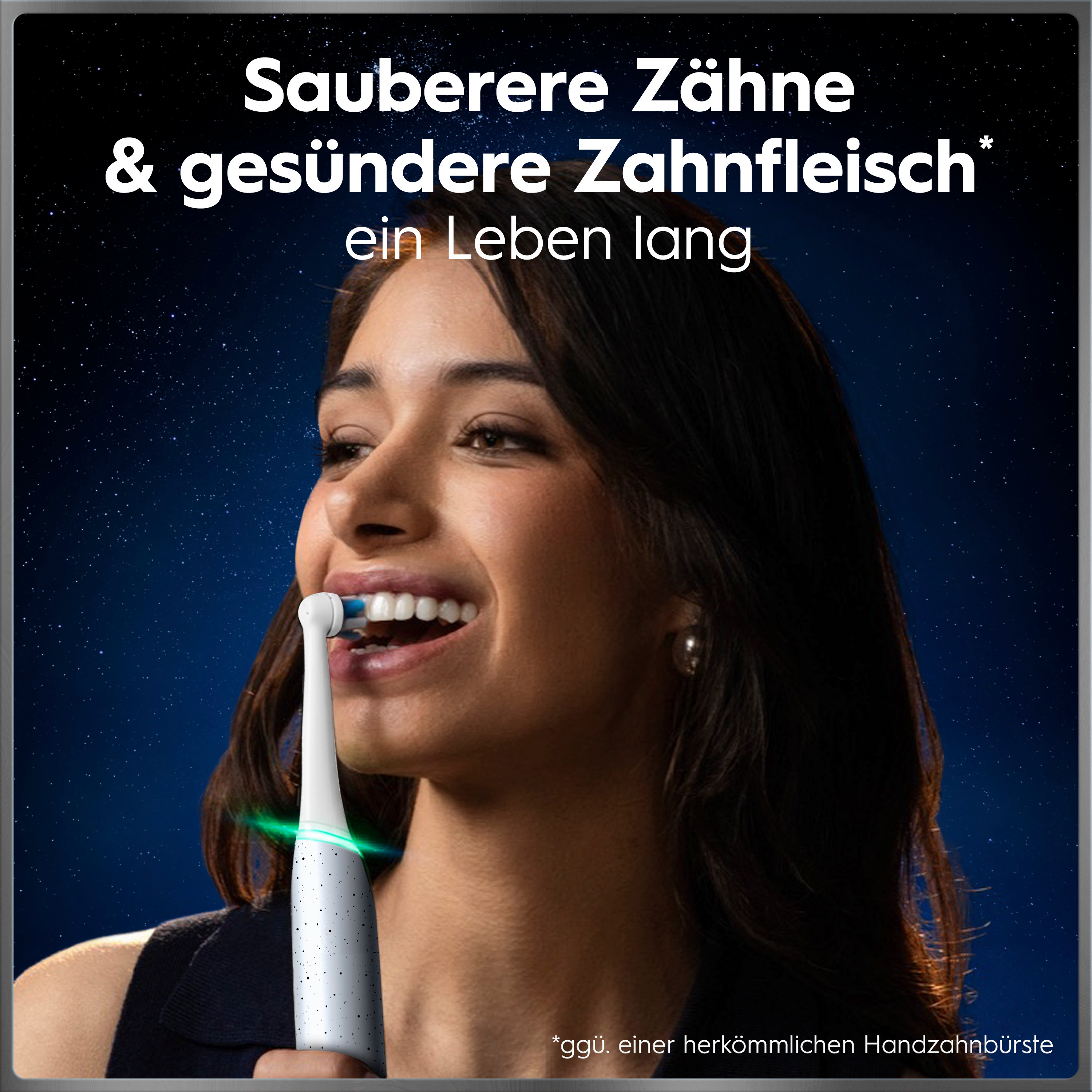 Une femme se brosse les dents avec une brosse à dents électrique devant un ciel étoilé.
