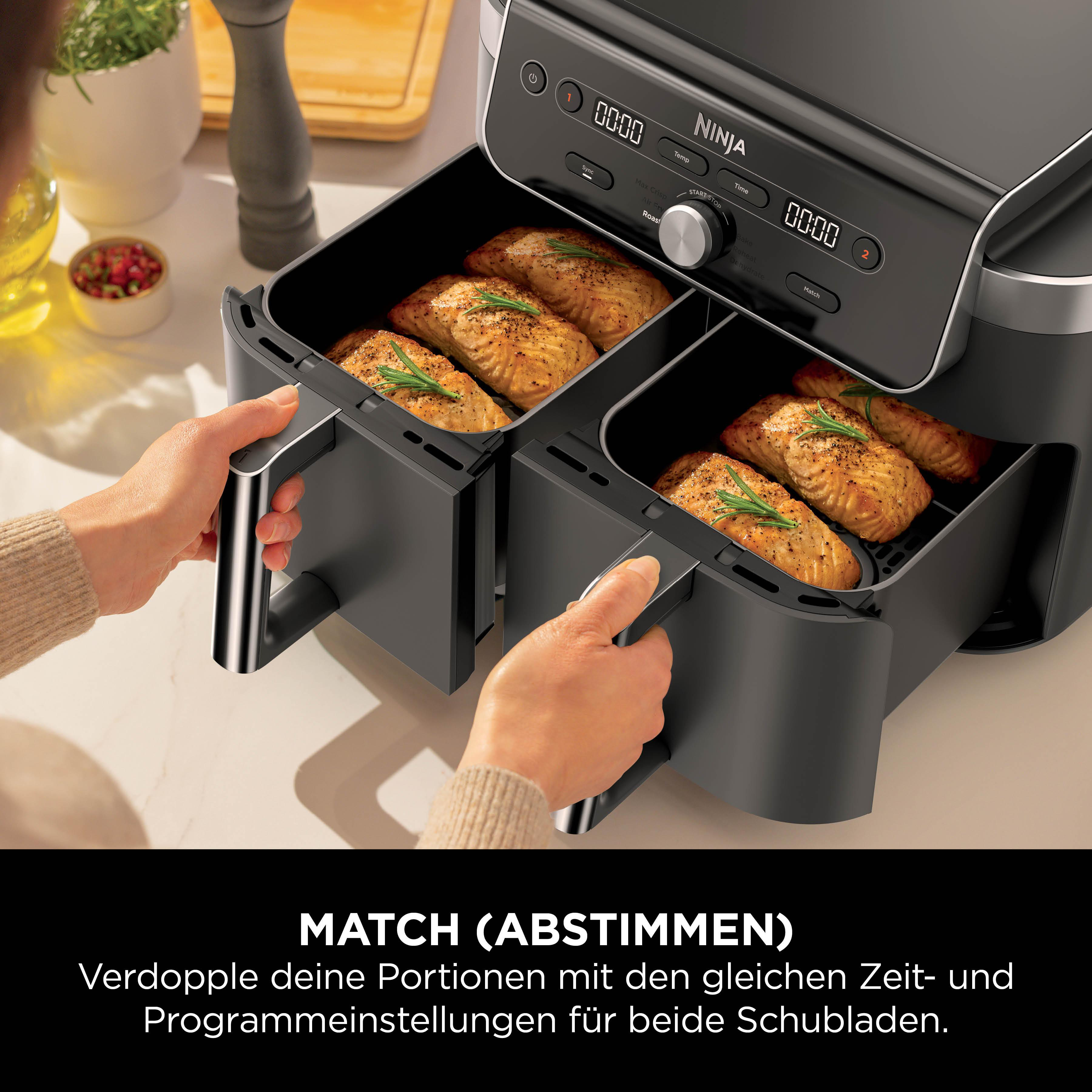 Doppelheißluftfritteuse mit zwei Schubladen, gefüllt mit gebratenem Lachs.