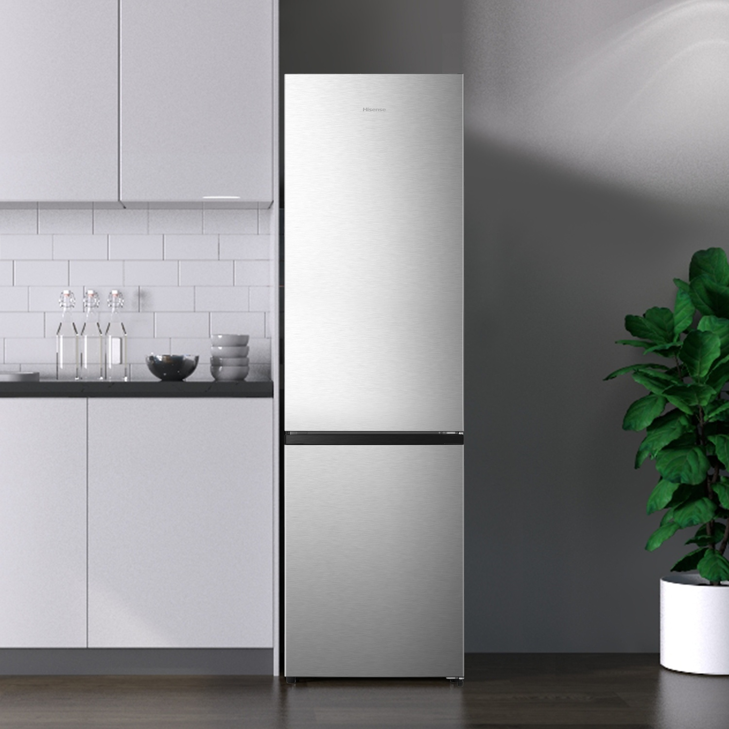 Un frigorifero Hisense argentato in una cucina moderna accanto a una pianta verde in vaso.