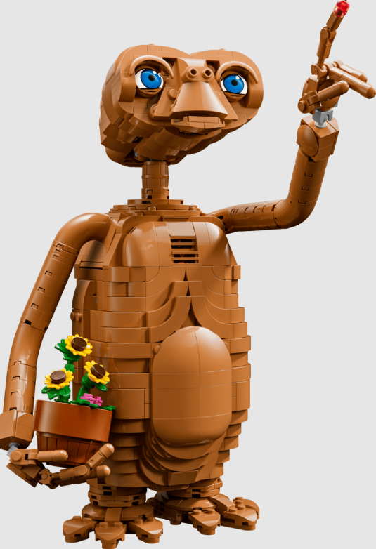 E.T. aus Lego-Steinen hält einen Blumentopf mit Sonnenblumen und zeigt auf etwas.