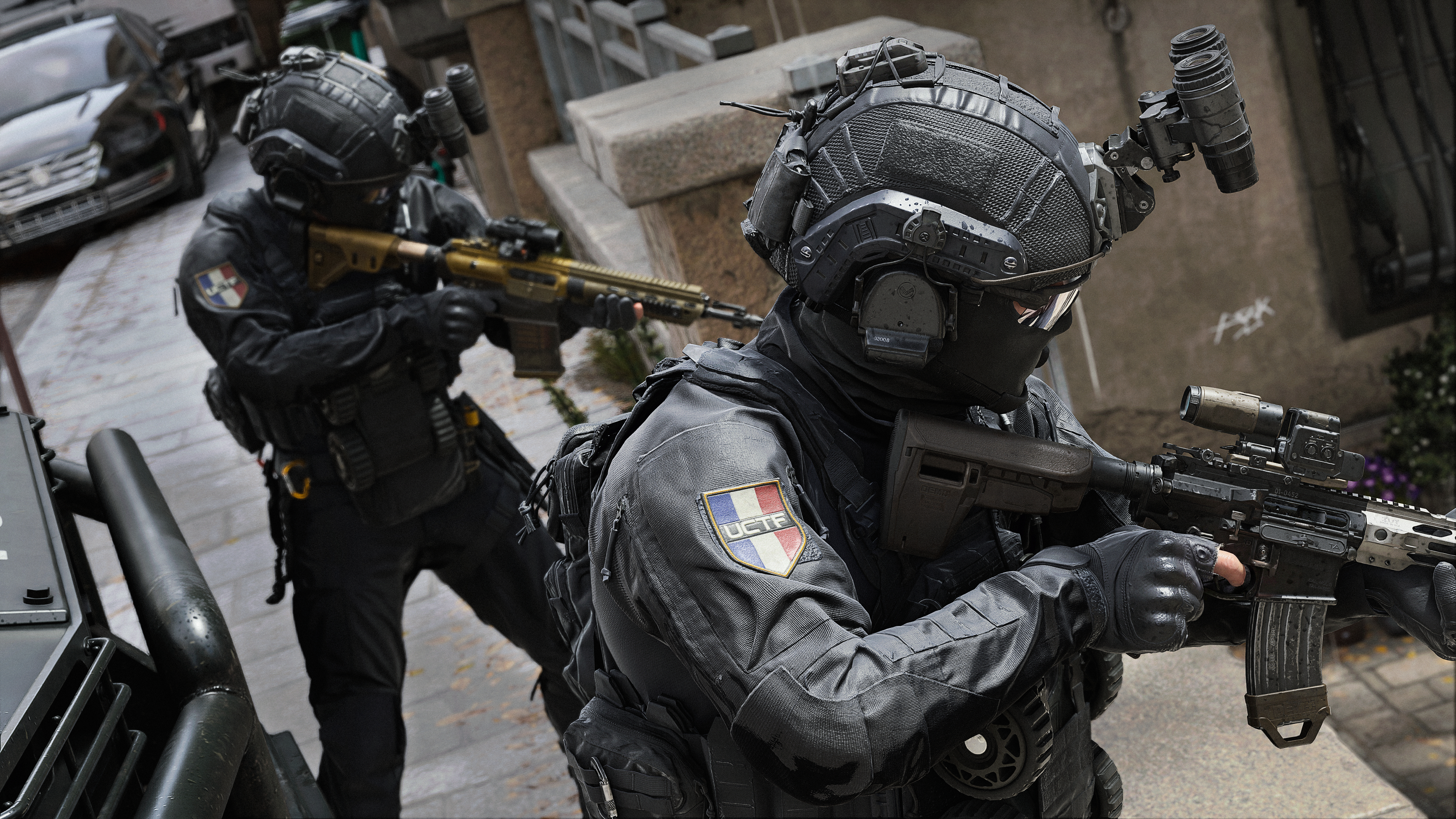 Zwei SWAT-Beamte in Schwarz mit Waffen auf einer Straße.