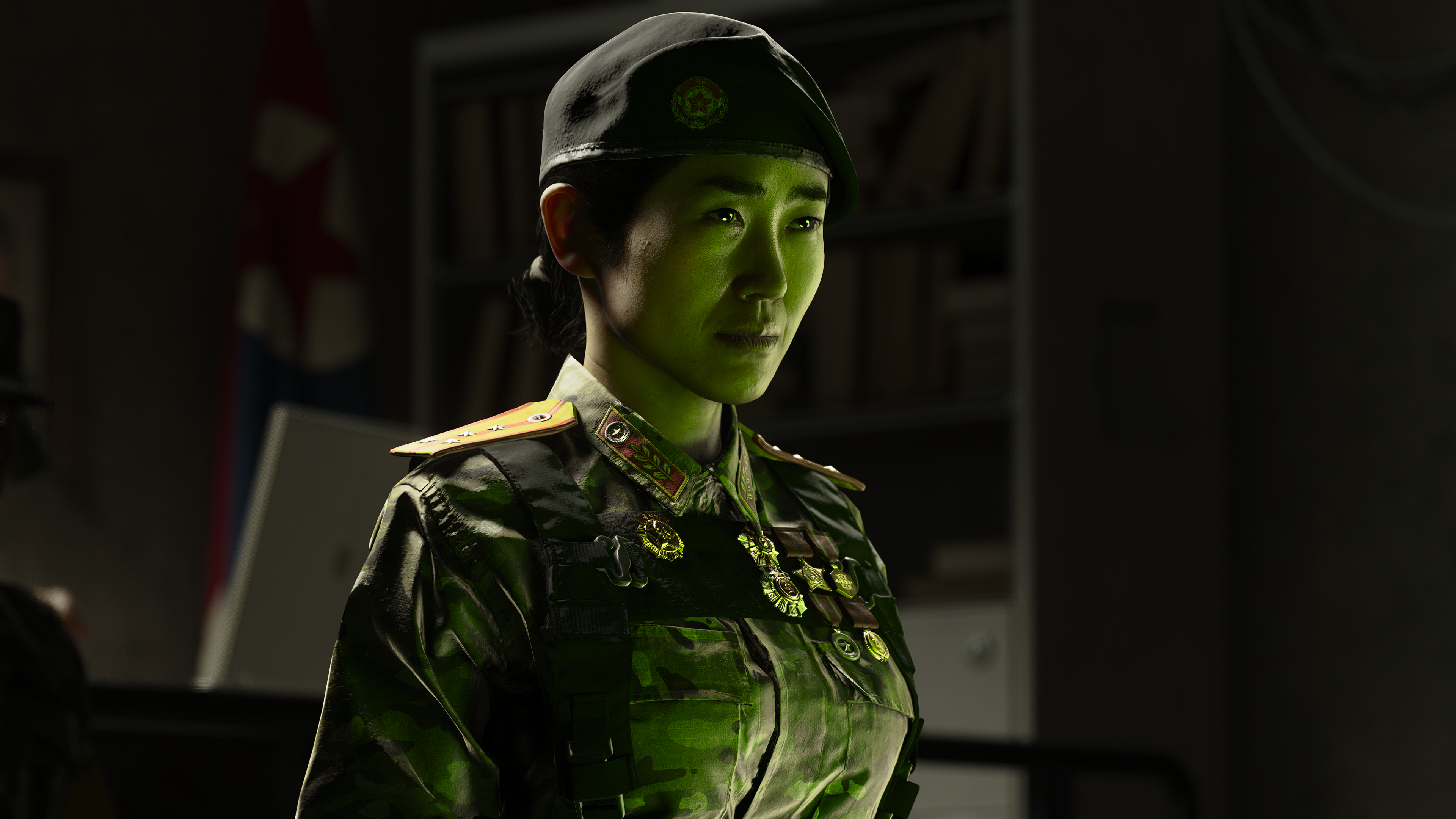 Eine Frau in Militäruniform mit Beret und Medaillen, im grünen Licht.