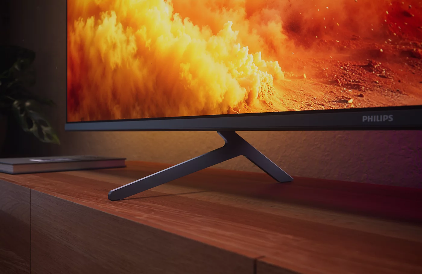 Egy Philips monitor tűzpiros, narancssárga és sárga absztrakt jelenetét mutatja. Fa állv ányon pihen.
