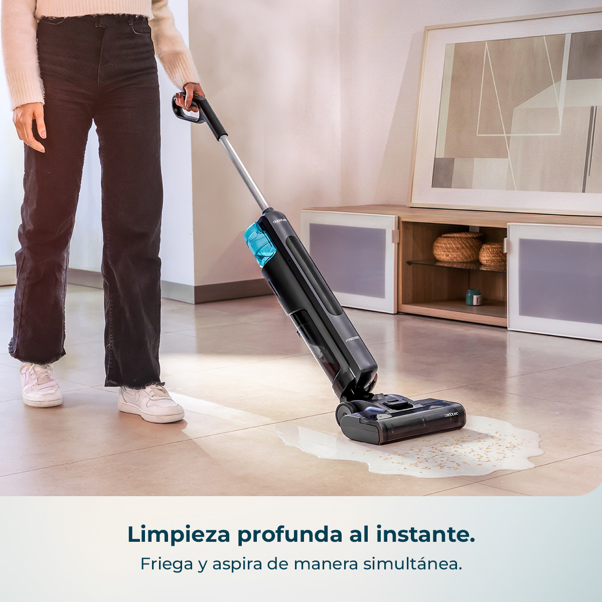 Una persona usa una aspiradora de líquidos y sólidos negra para limpiar un derrame en un suelo claro.