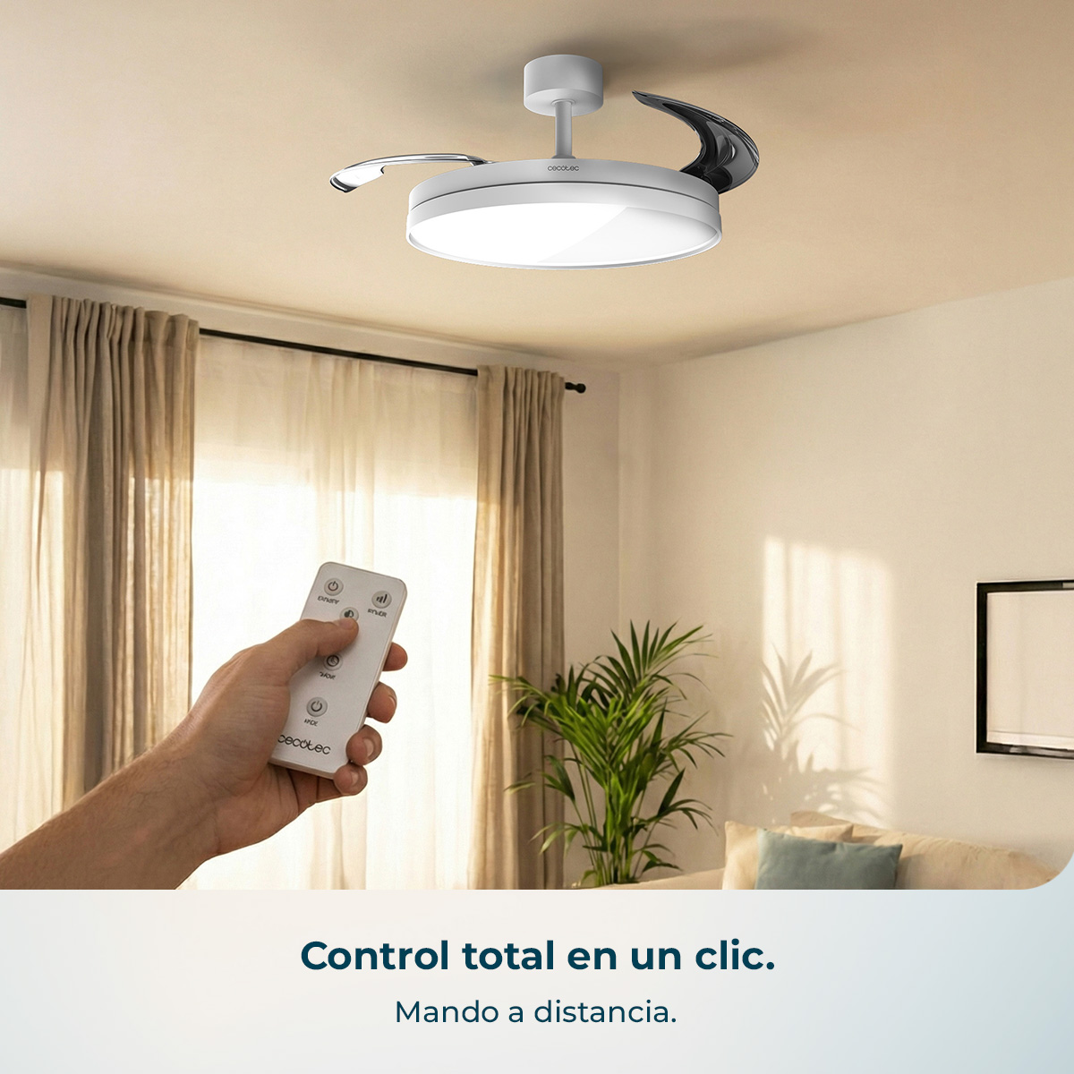 Una mano sostiene un mando a distancia blanco delante de un ventilador de techo con luz.