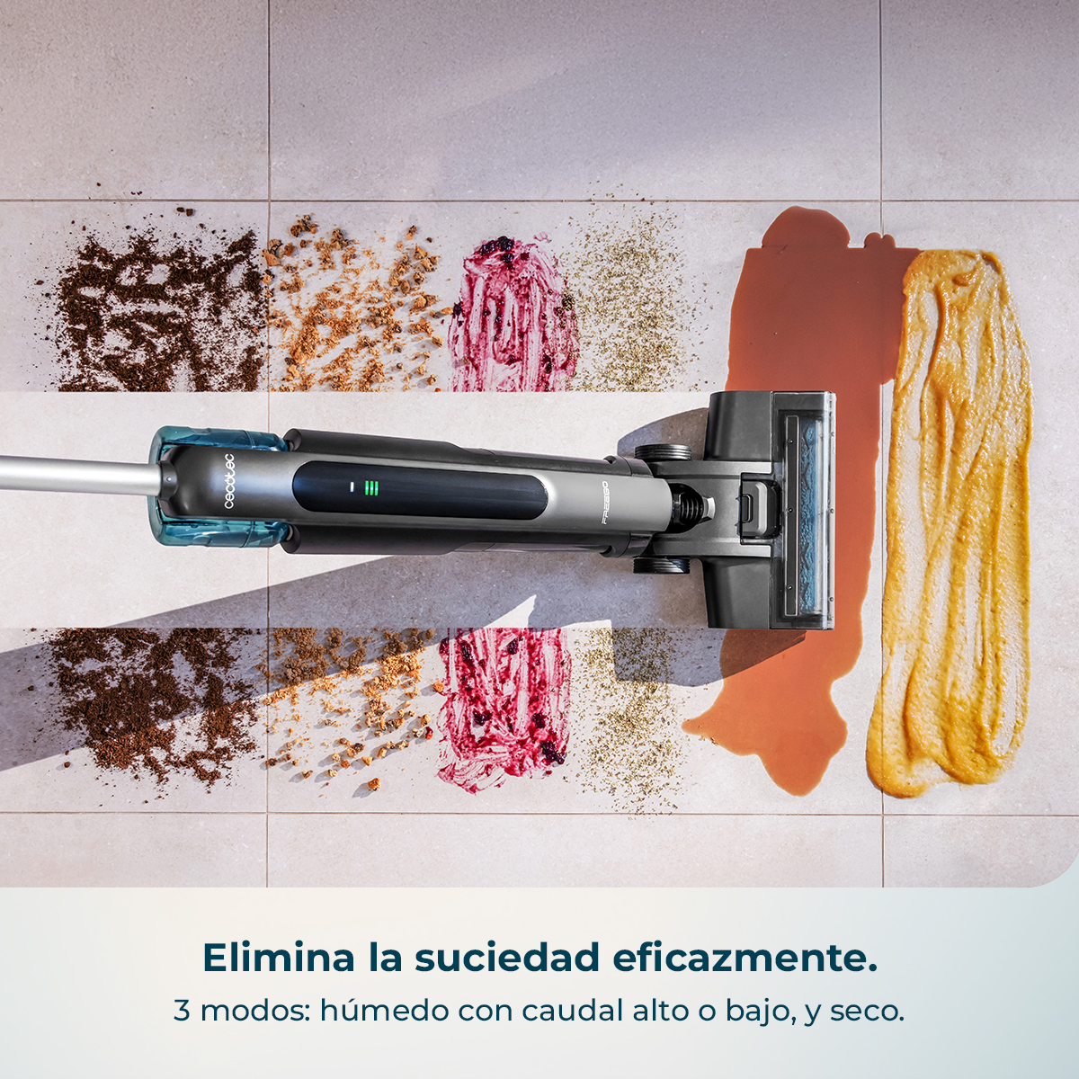 Una aspiradora limpia derrames y suciedad seca sobre baldosas claras.