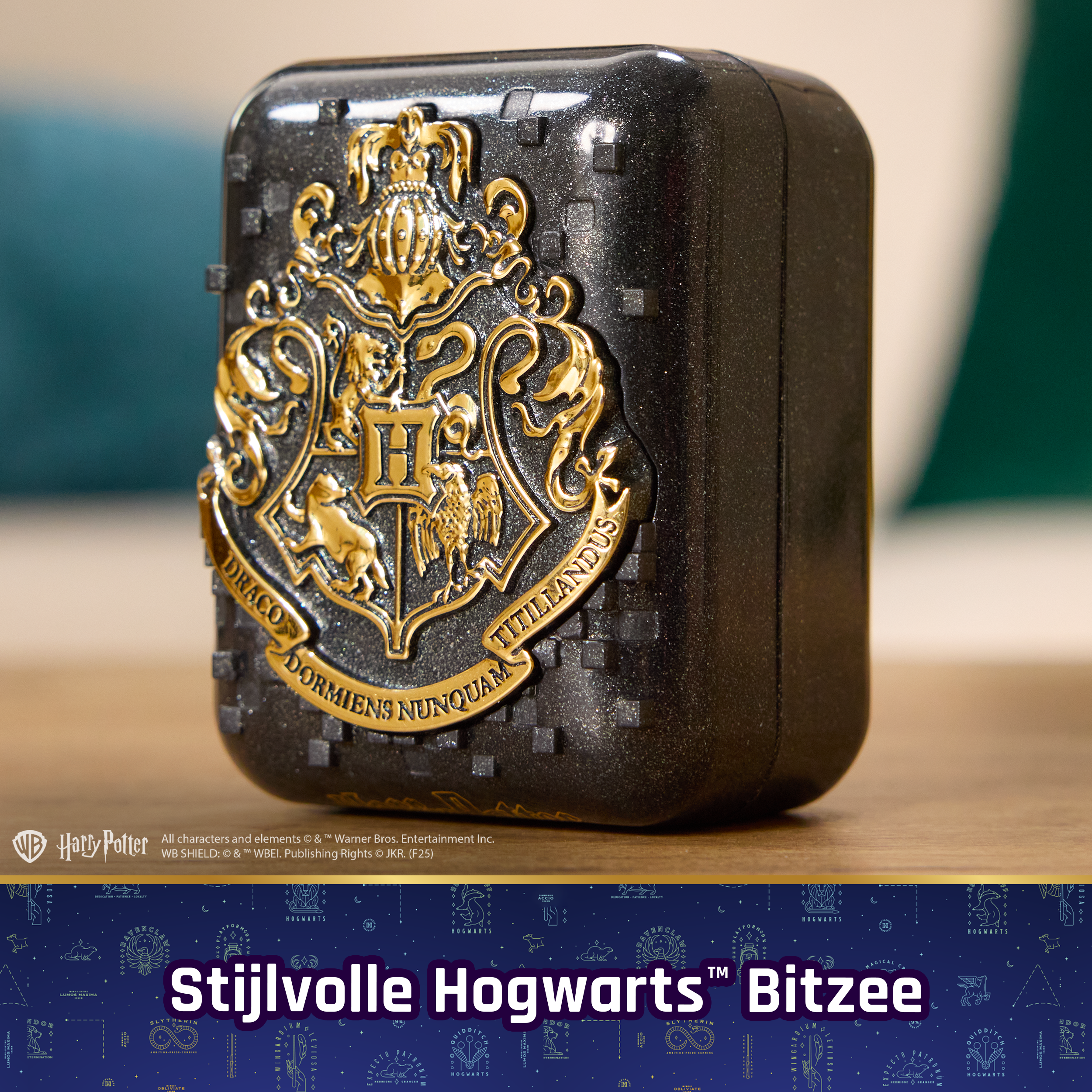 Czarne etui ze złotym herbem Hogwartu.