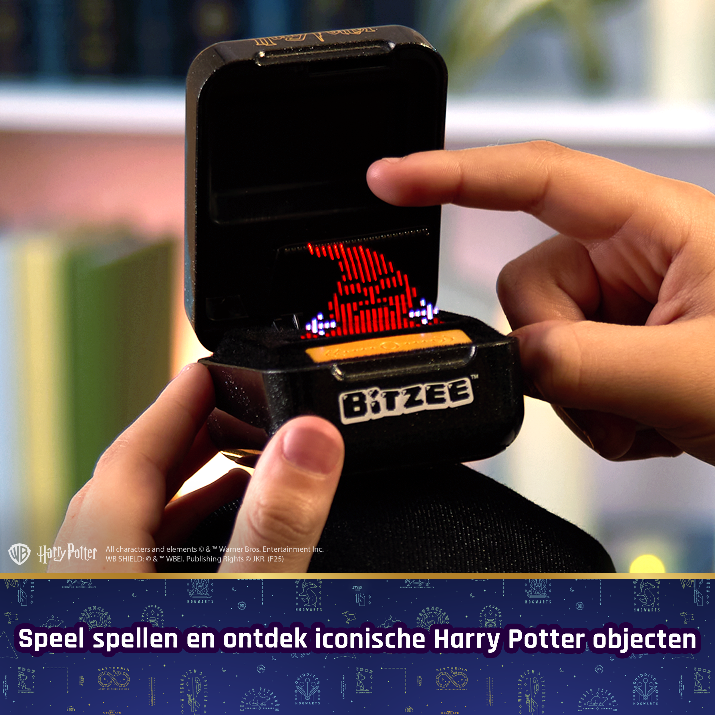 Ręce trzymające czarną zabawkę Bitzee z motywem Harry'ego Pottera i wyświetlaczem czerwonego kapelusza.