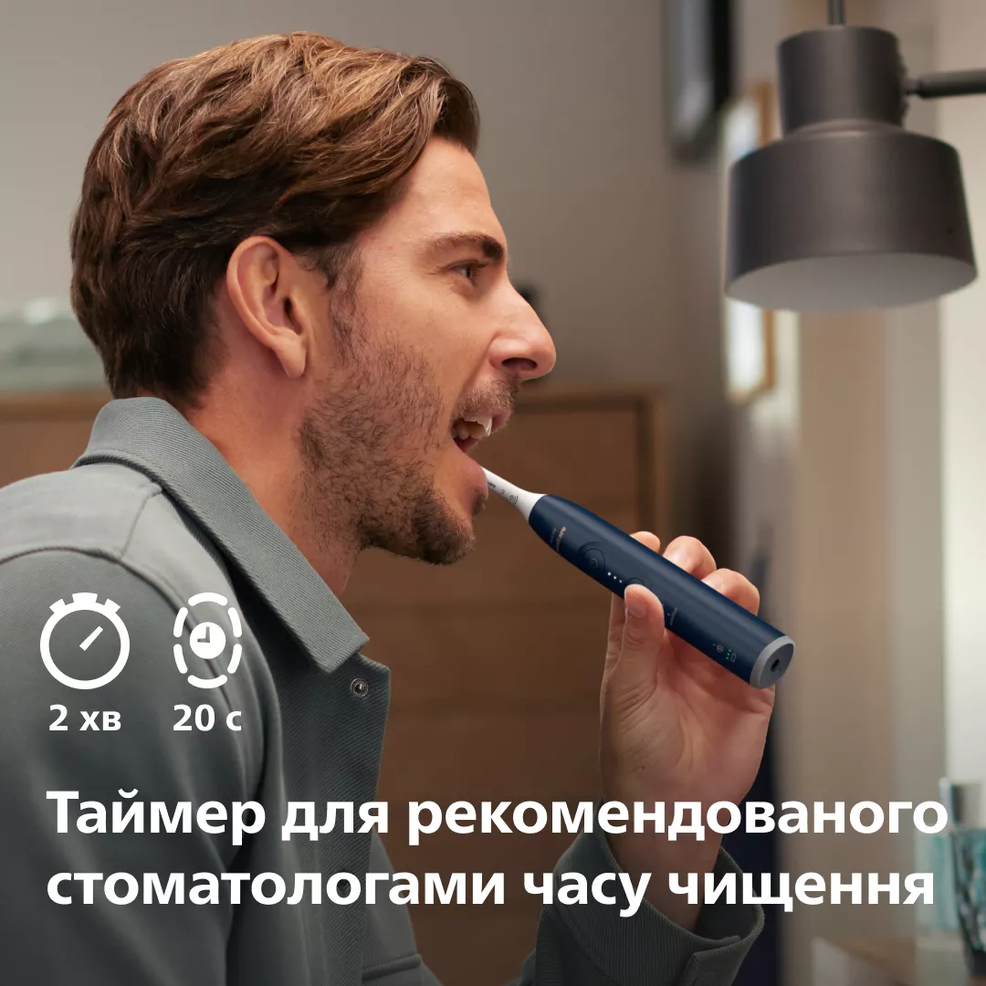 Mężczyzna myje zęby szczoteczką elektryczną. Ikony timera: 2 min i 20 sek.