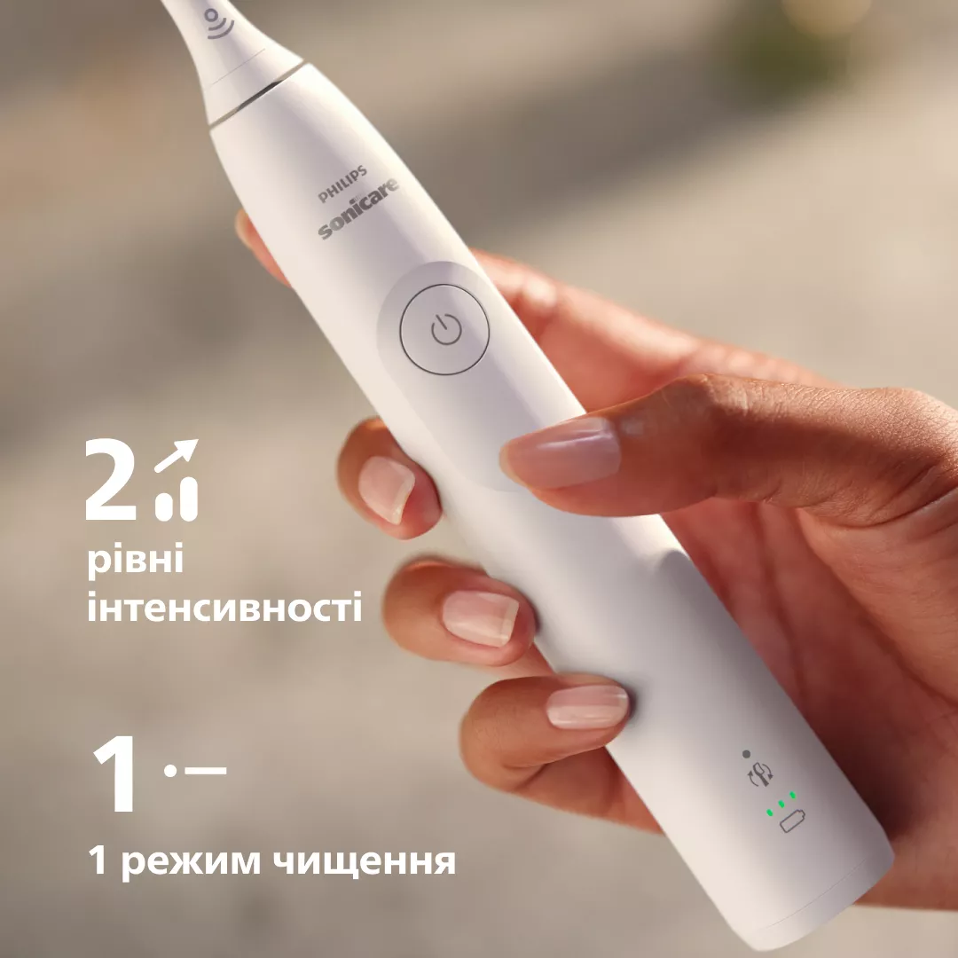 Dłoń trzyma białą szczoteczkę elektryczną z napisem "Philips Sonicare".