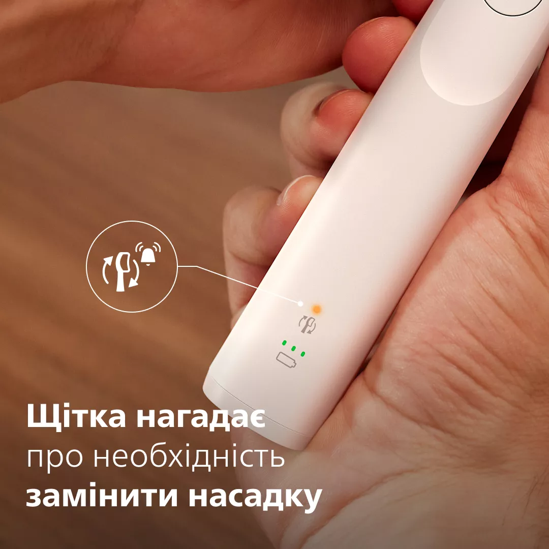 Główka szczoteczki elektrycznej z ikoną ostrzeżenia i baterii.