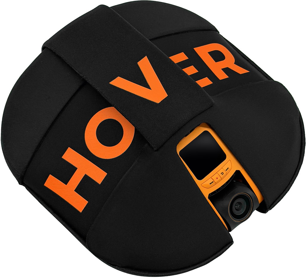 Ein schwarzer Überzug mit orangefarbenem Schriftzug HOVER, der eine orangefarbene Kamera mit Bildschirm bedeckt.