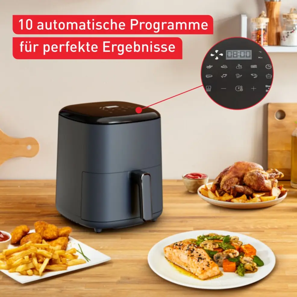 Friteuse à air gris foncé avec plats comme poulet, saumon et frites.