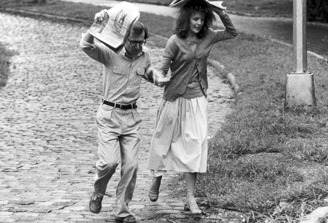 Ein Mann und eine Frau rennen im Regen, sie benutzen Zeitungen als Regenschirme.
