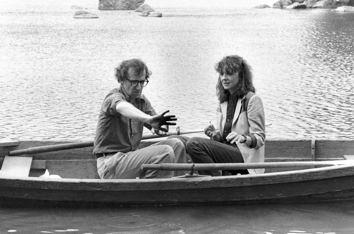 Mann und Frau sitzen in einem Boot auf dem Wasser. Felsen im Hintergrund.