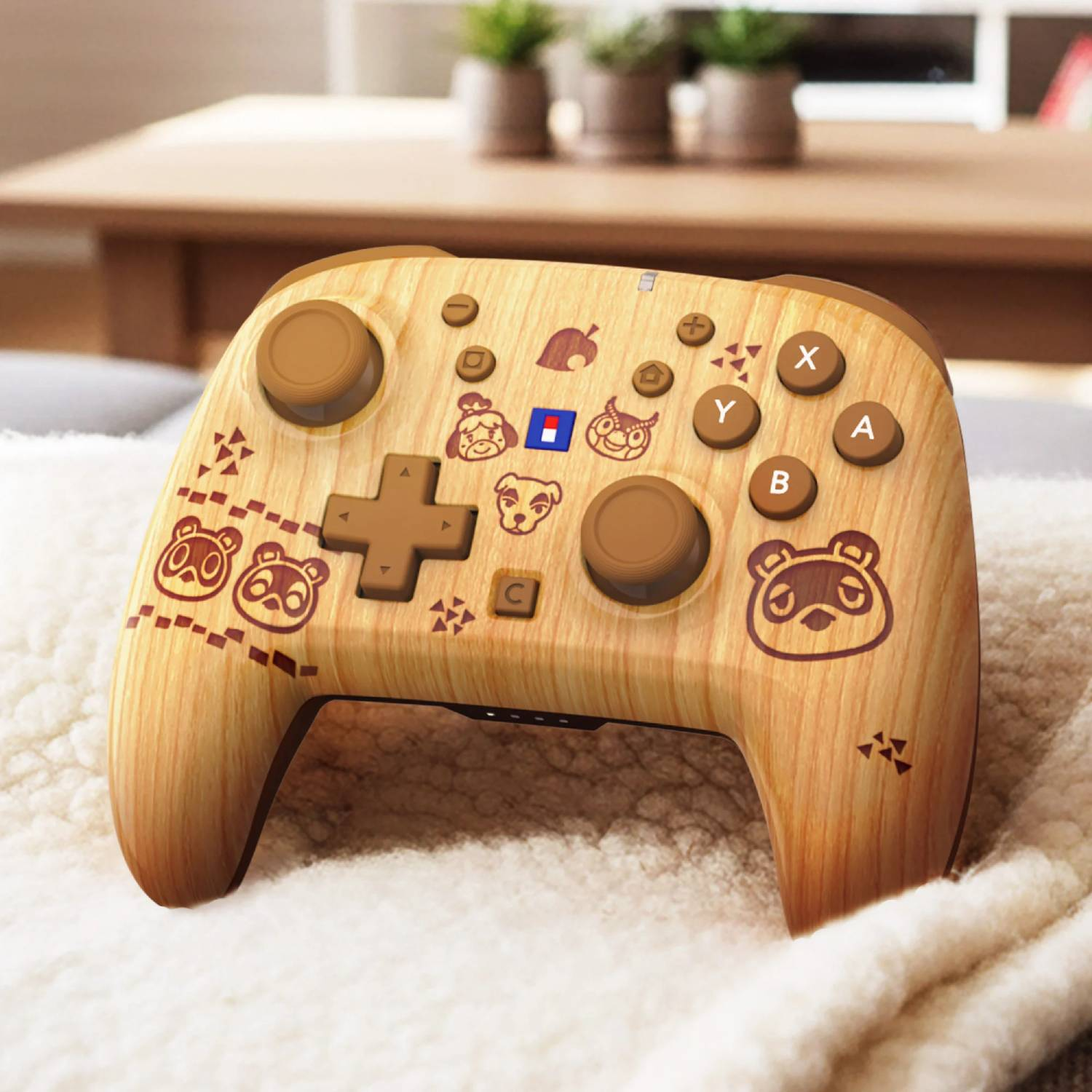 Un controlador de veta de madera con diseños de Animal Crossing sobre una manta blanca.
