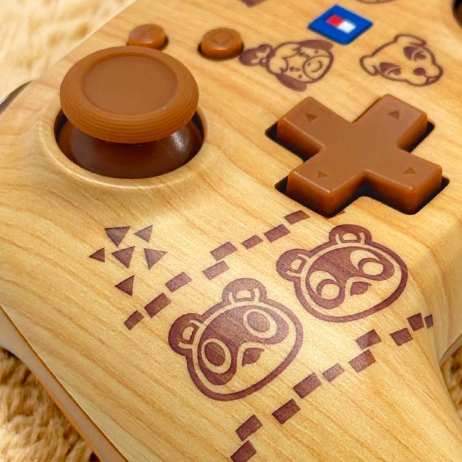 Un mando de Nintendo Switch de madera con personajes de Animal Crossing e iconos de mapa.