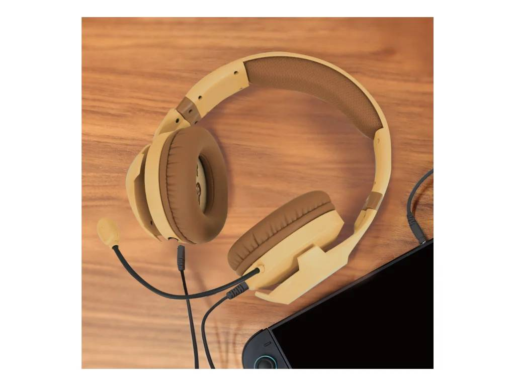 Auriculares beige con almohadillas marrones y micrófono sobre mesa de madera junto a smartphone.
