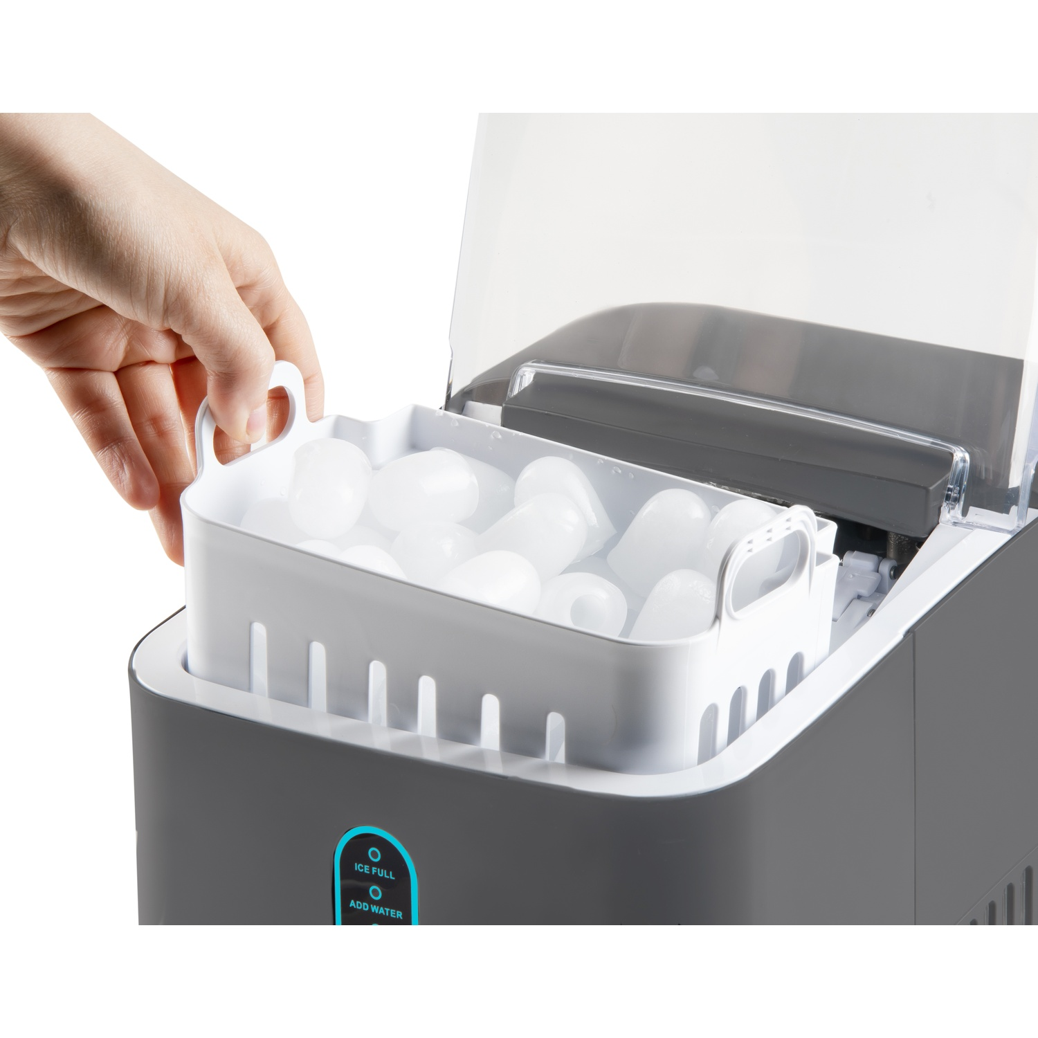 Een hand tilt een ijsbak vol ijsblokjes uit een ijsmachine.