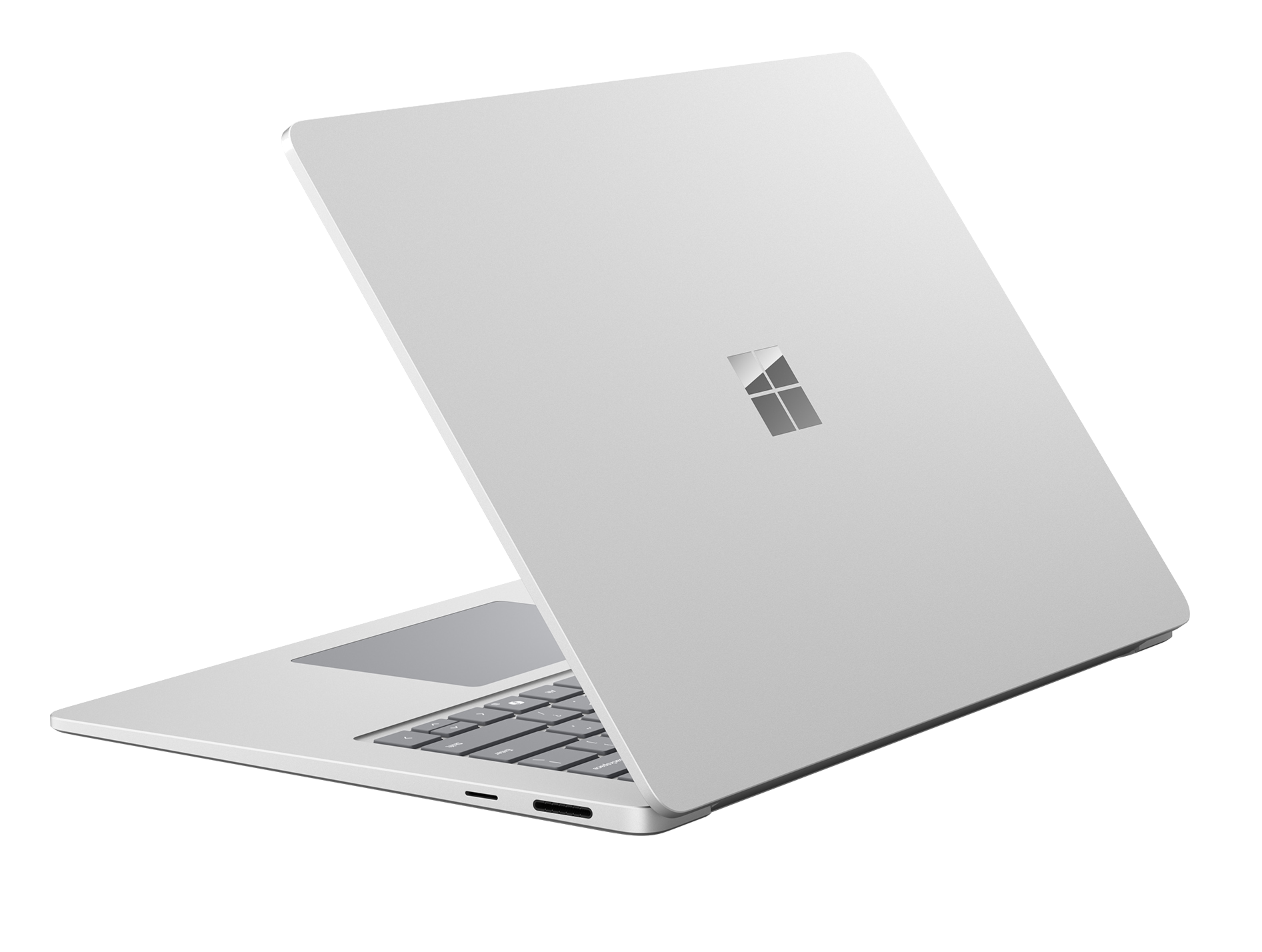 Un portátil plateado con el logo de Microsoft en la tapa, sobre fondo negro.