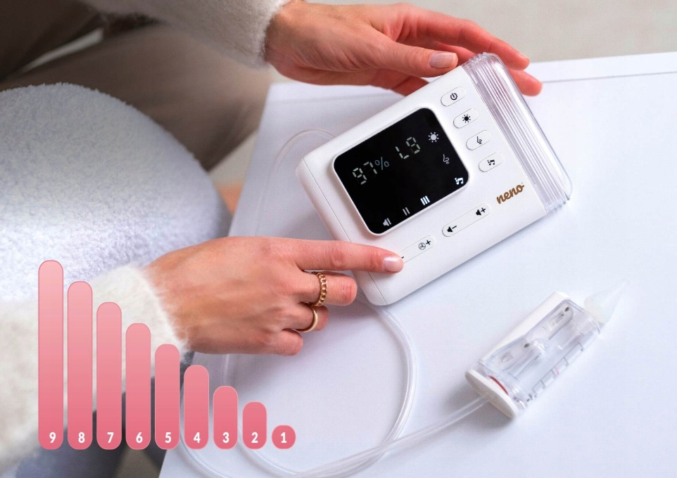 Biały aspirator do nosa dla niemowląt z jednostką sterującą i wyświetlaczem. Ręce obsługują urządzenie.