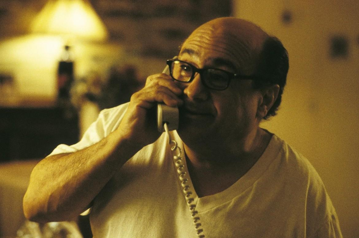 Ein Glatzkopf mit Brille telefoniert mit einem Schnurtelefon. Er trägt ein weißes T-Shirt.