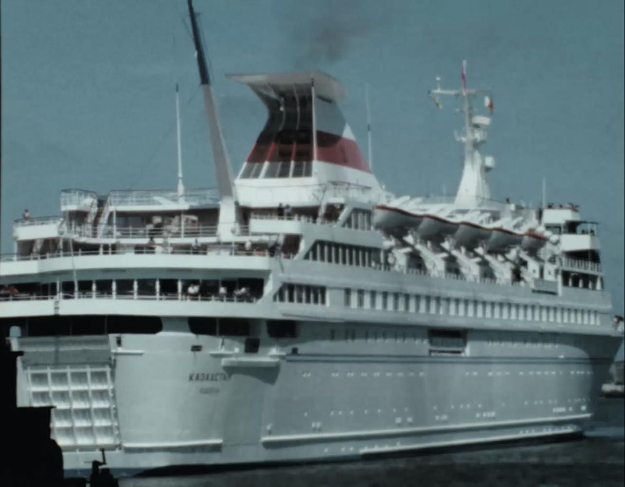 Ein großes weißes Passagierschiff mit roten Akzenten auf dem Schornstein.