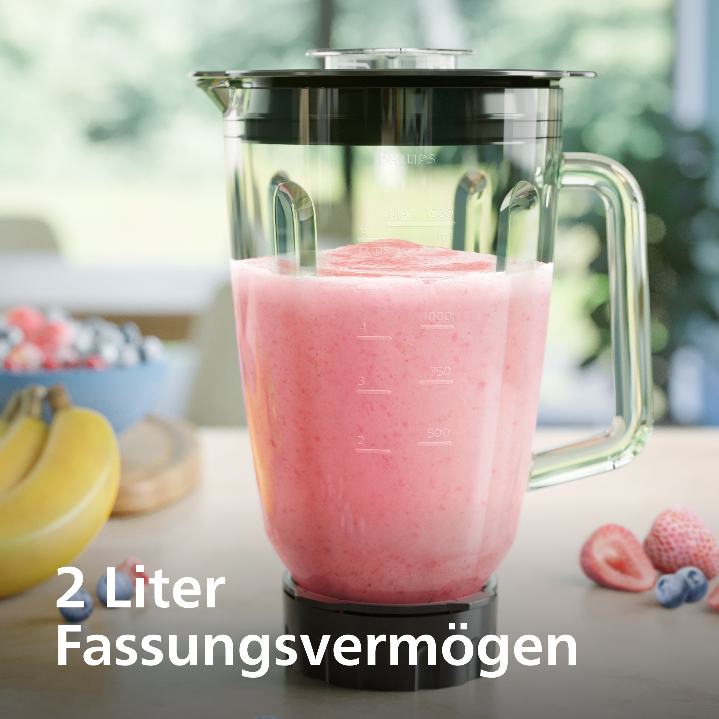 Ein Mixer mit 2L Fassungsvermögen, gefüllt mit rosafarbenem Smoothie, daneben Früchte.
