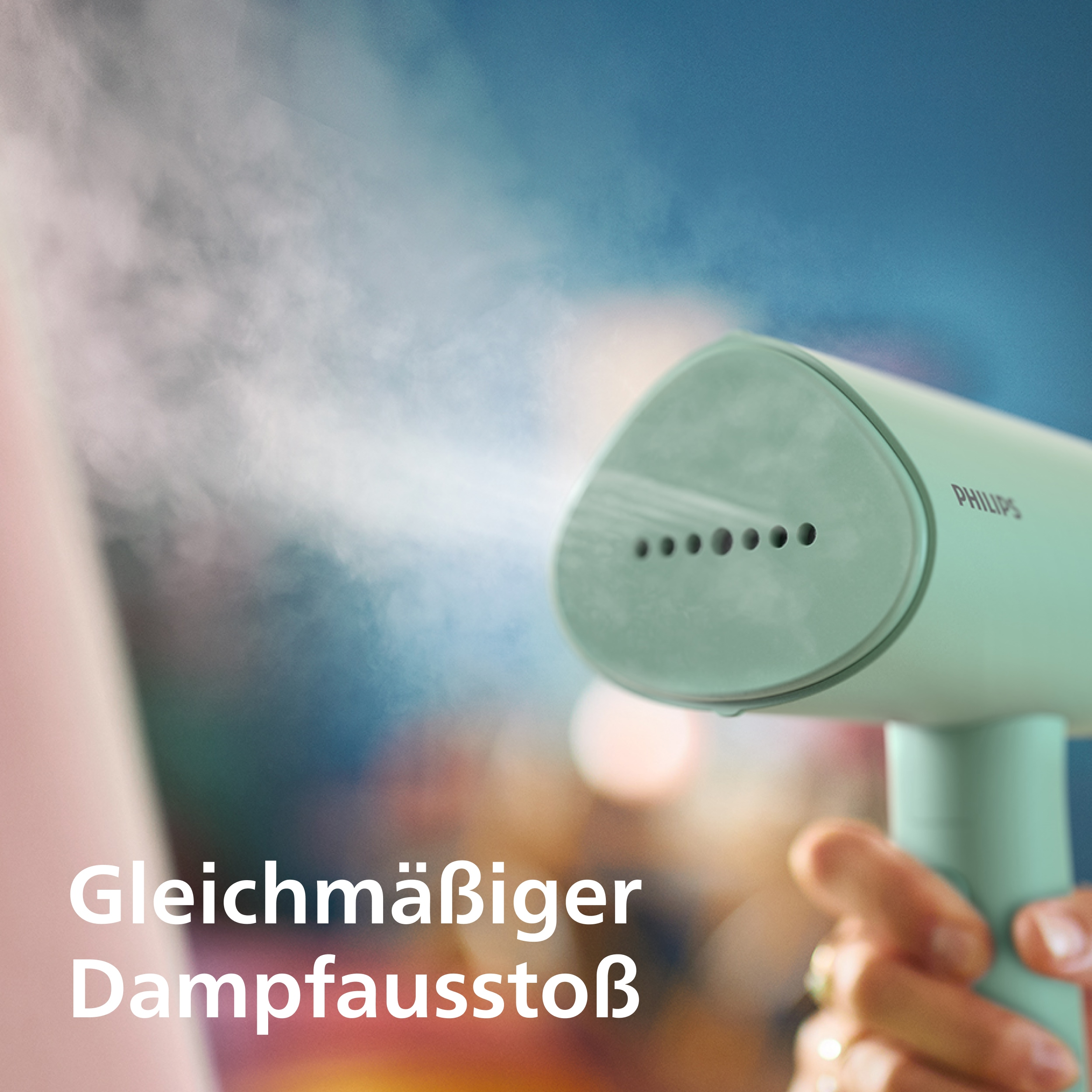 Eine grüne Philips Dampfbürste sprüht Dampf auf ein rosafarbenes Tuch.