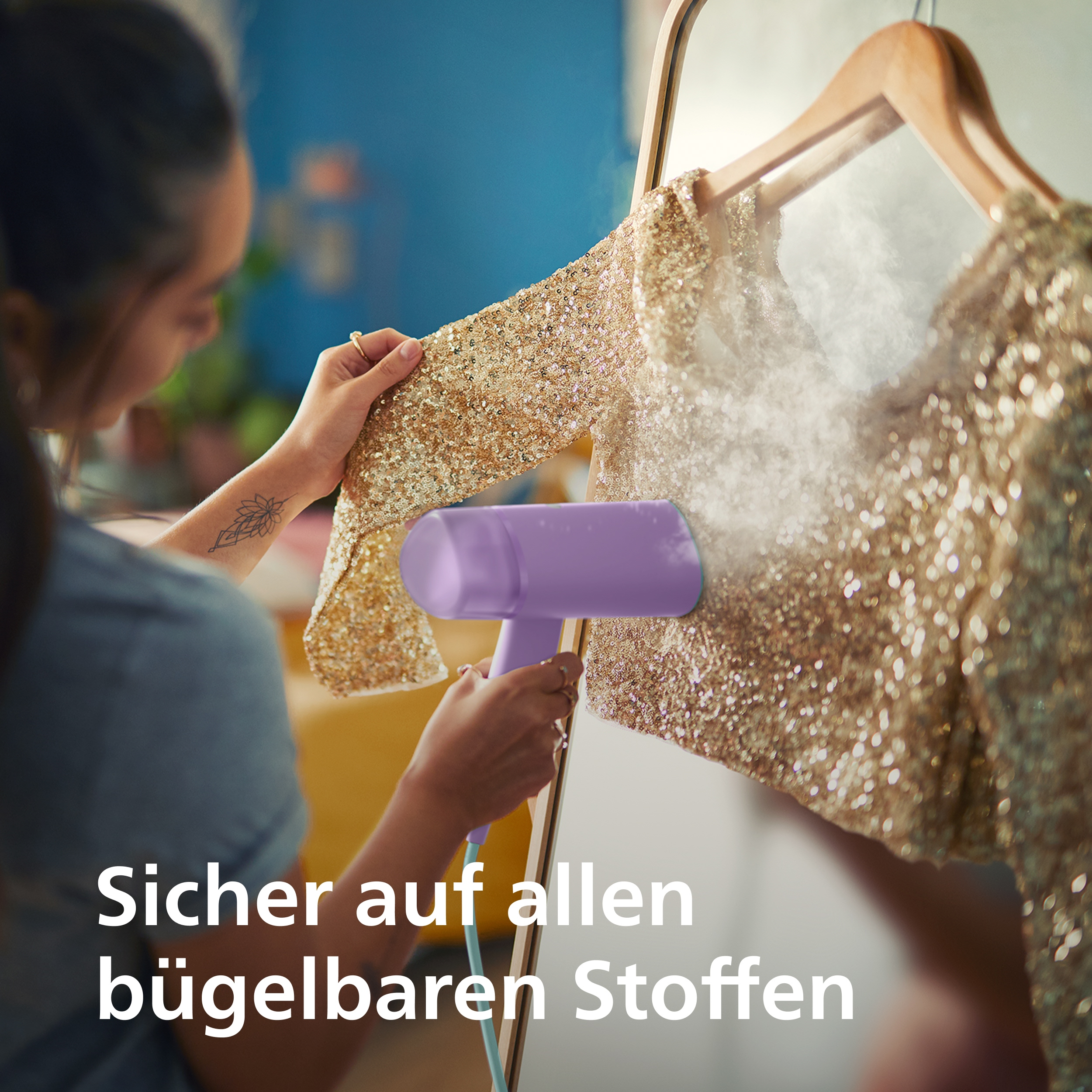 Frau glättet goldfarbenes Paillettenkleid mit Dampfglätter.