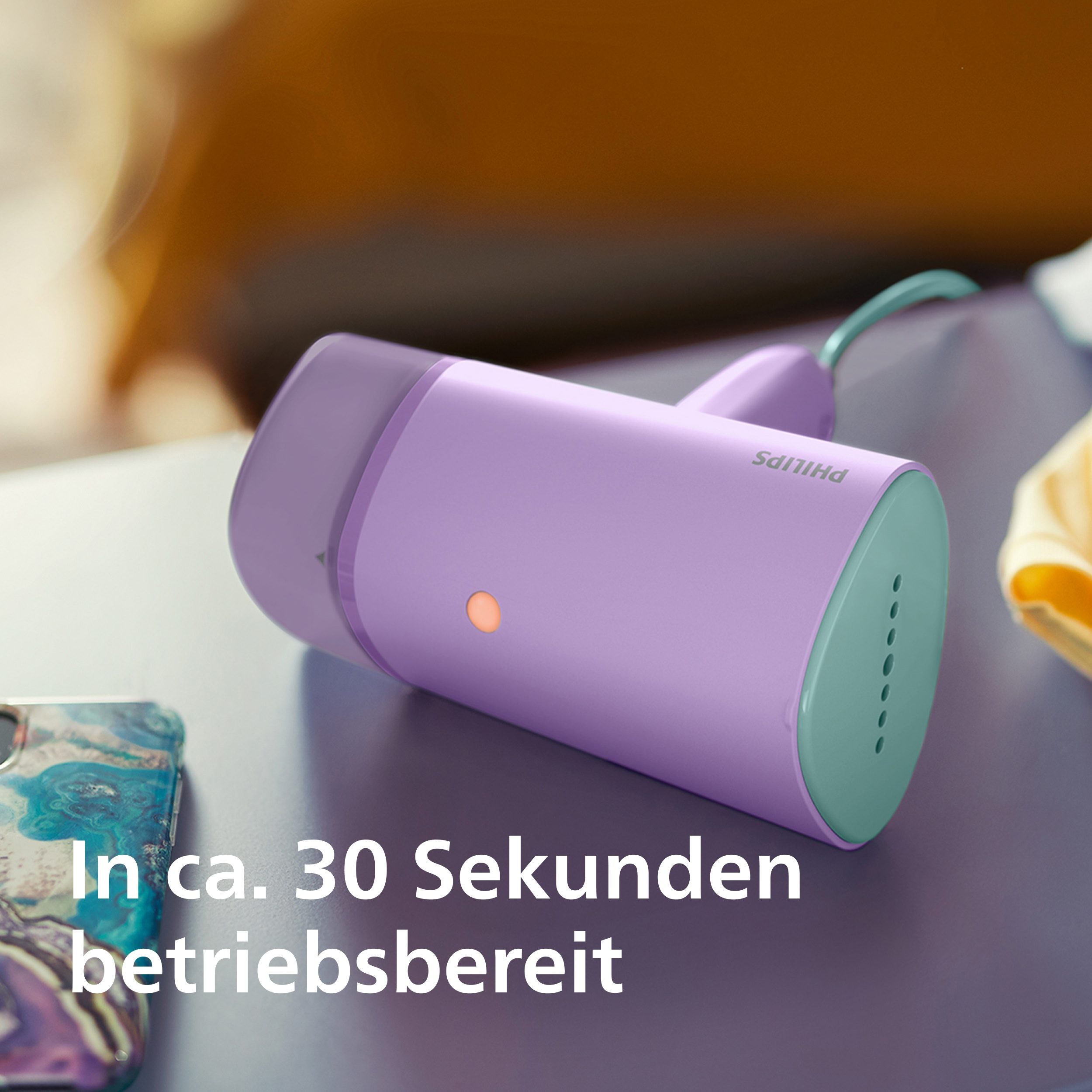 Ein lilafarbener Philips Handdampfer liegt auf einer Oberfläche.